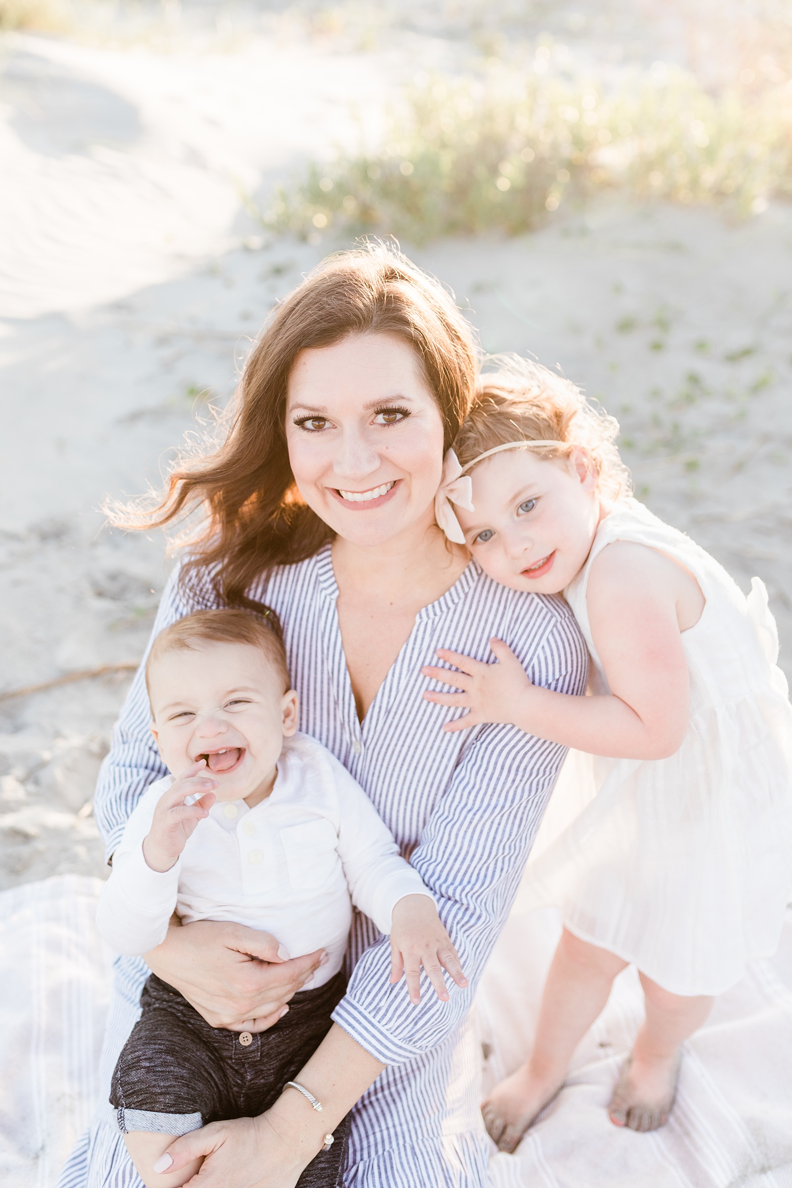 Mother with two kids on beach during family session by Charleston Family Photographer, Caitlyn Motycka Photography