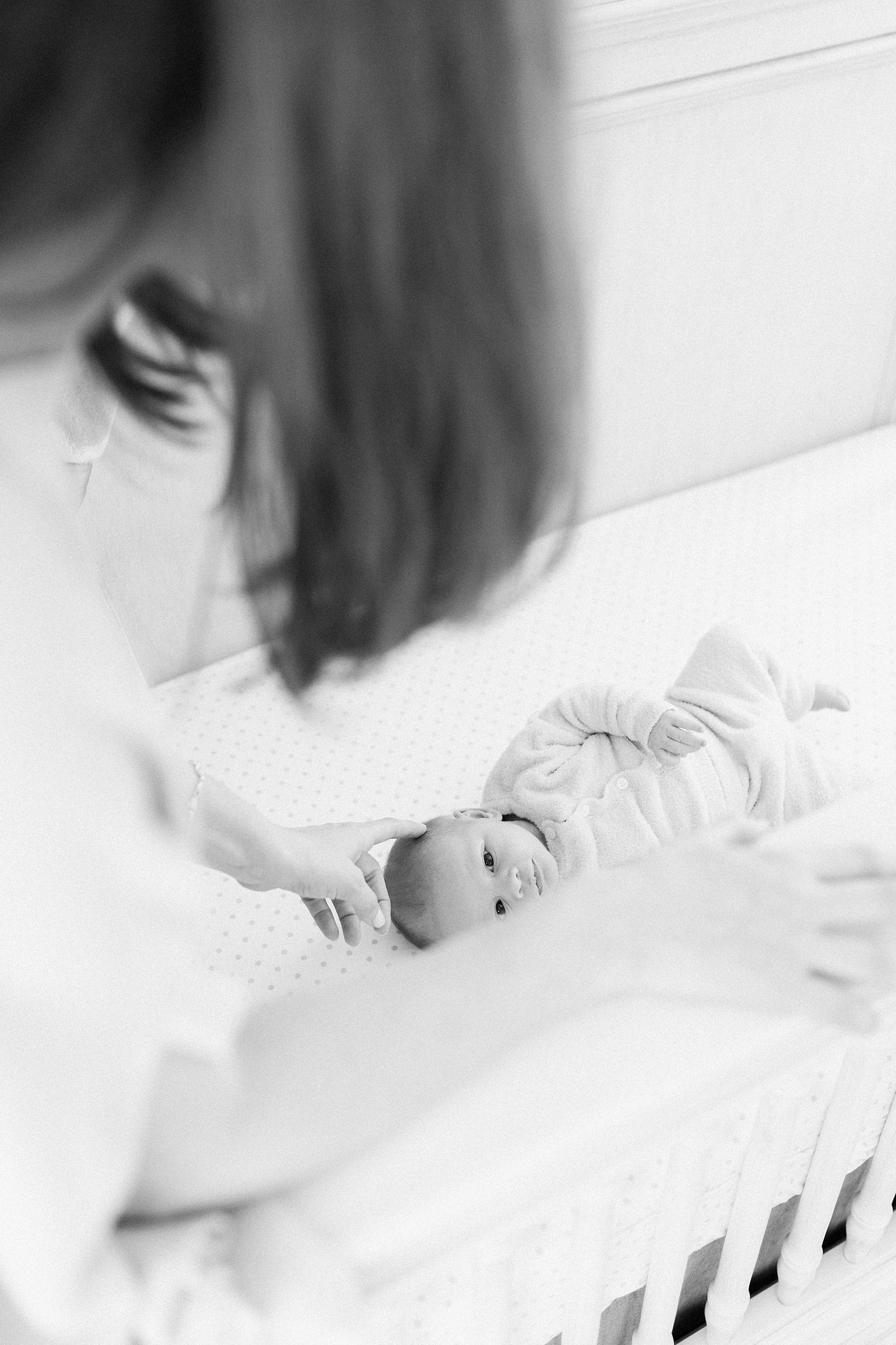 Black and white lifestyle newborn image of baby in crib by Charleston Newborn Photographer, Caitlyn Motycka Photography
