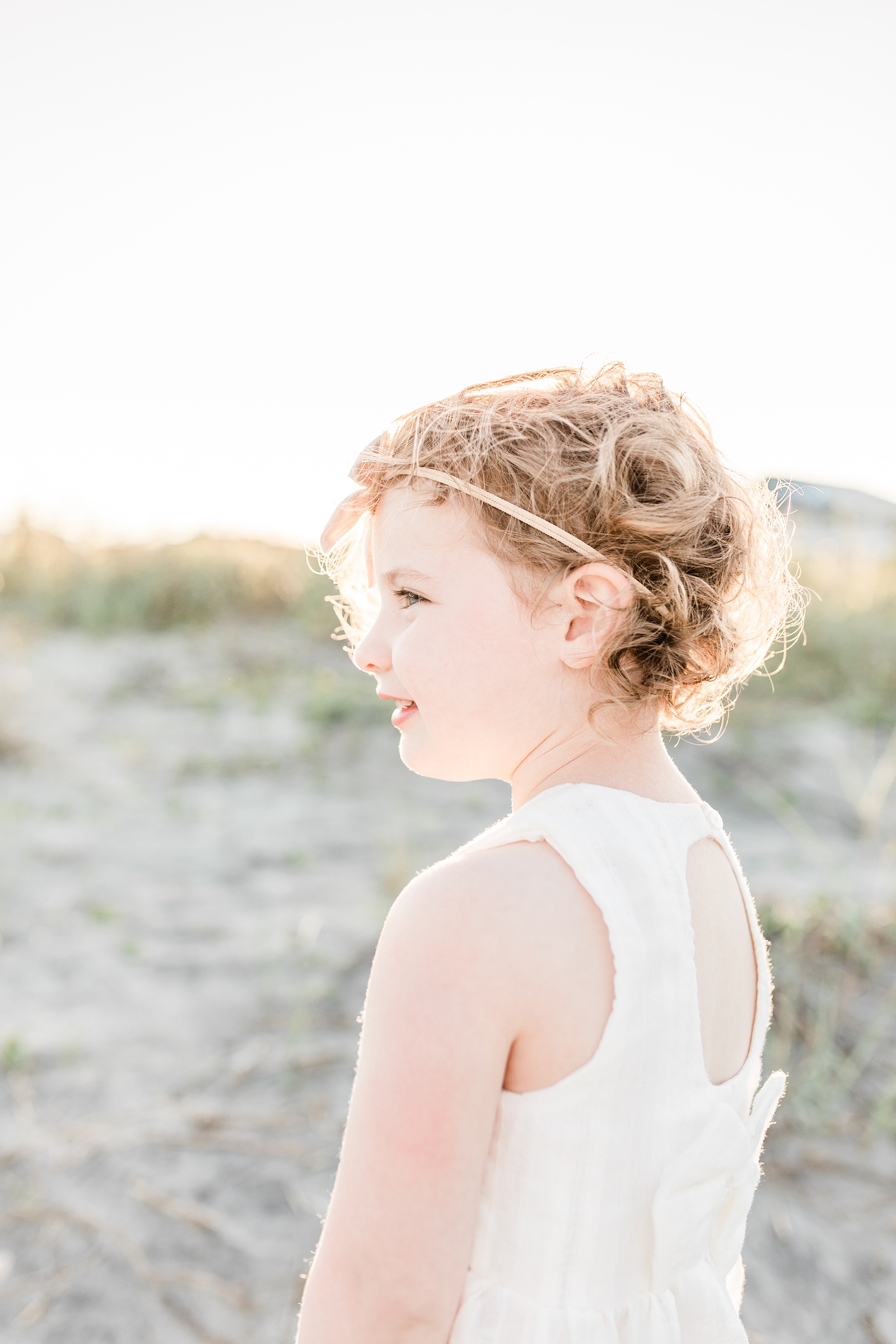 Silhouette of Little girl with curly hair during beach family session by Charleston Family Photographer, Caitlyn Motycka Photography