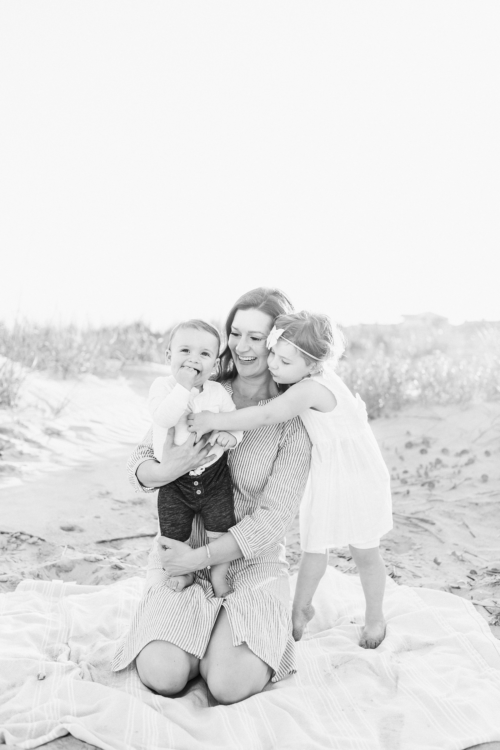 Black and white image of Mom and kids during beach family session on Isle of Palms | Caitlyn Motycka Photography