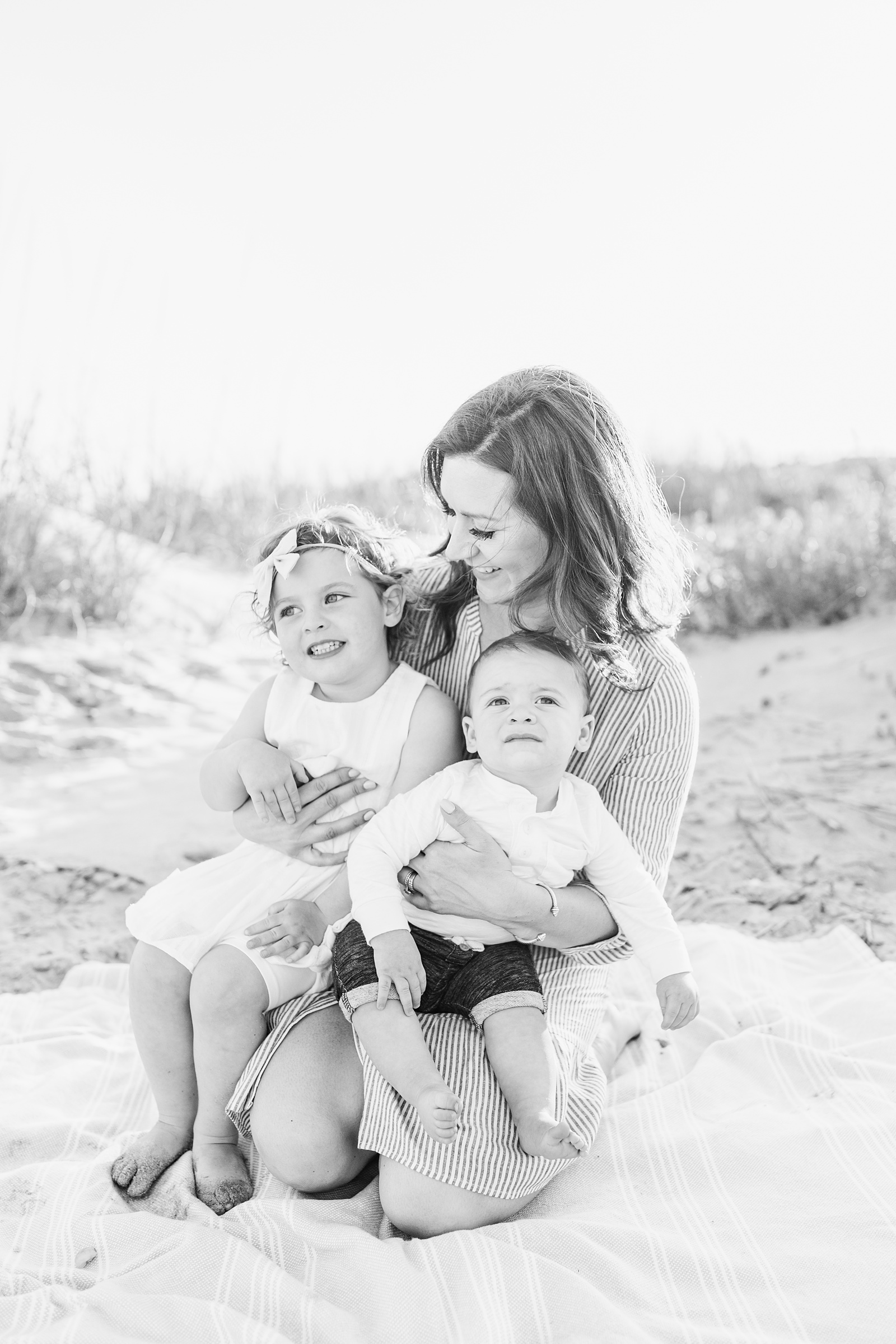 Black and white image of Mom and kids during beach family session outside of Charleston, SC | Caitlyn Motycka Photography