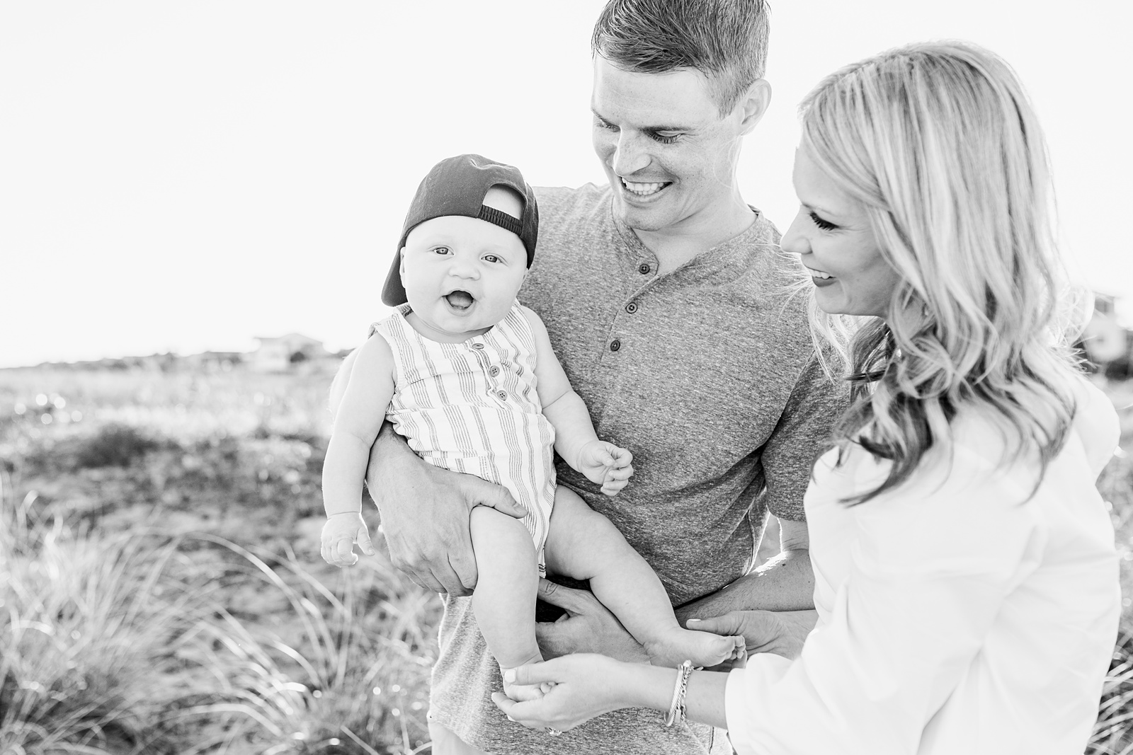 Black and white image of family with baby on Isle of Palms during beach family session by Caitlyn Motycka Photography