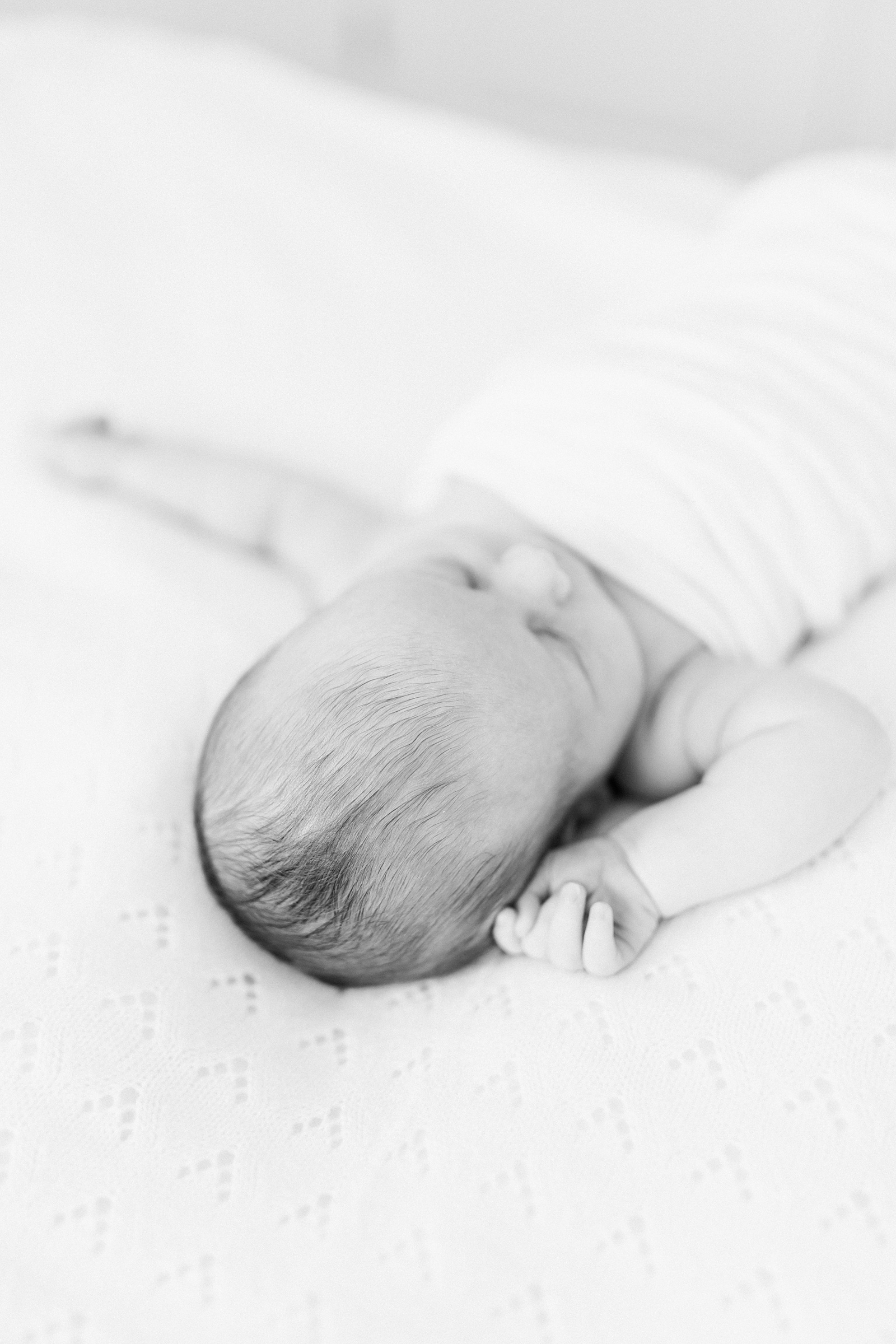 Black and white image of baby during lifestyle newborn session by Charleston Newborn Photographer, Caitlyn Motycka Photography