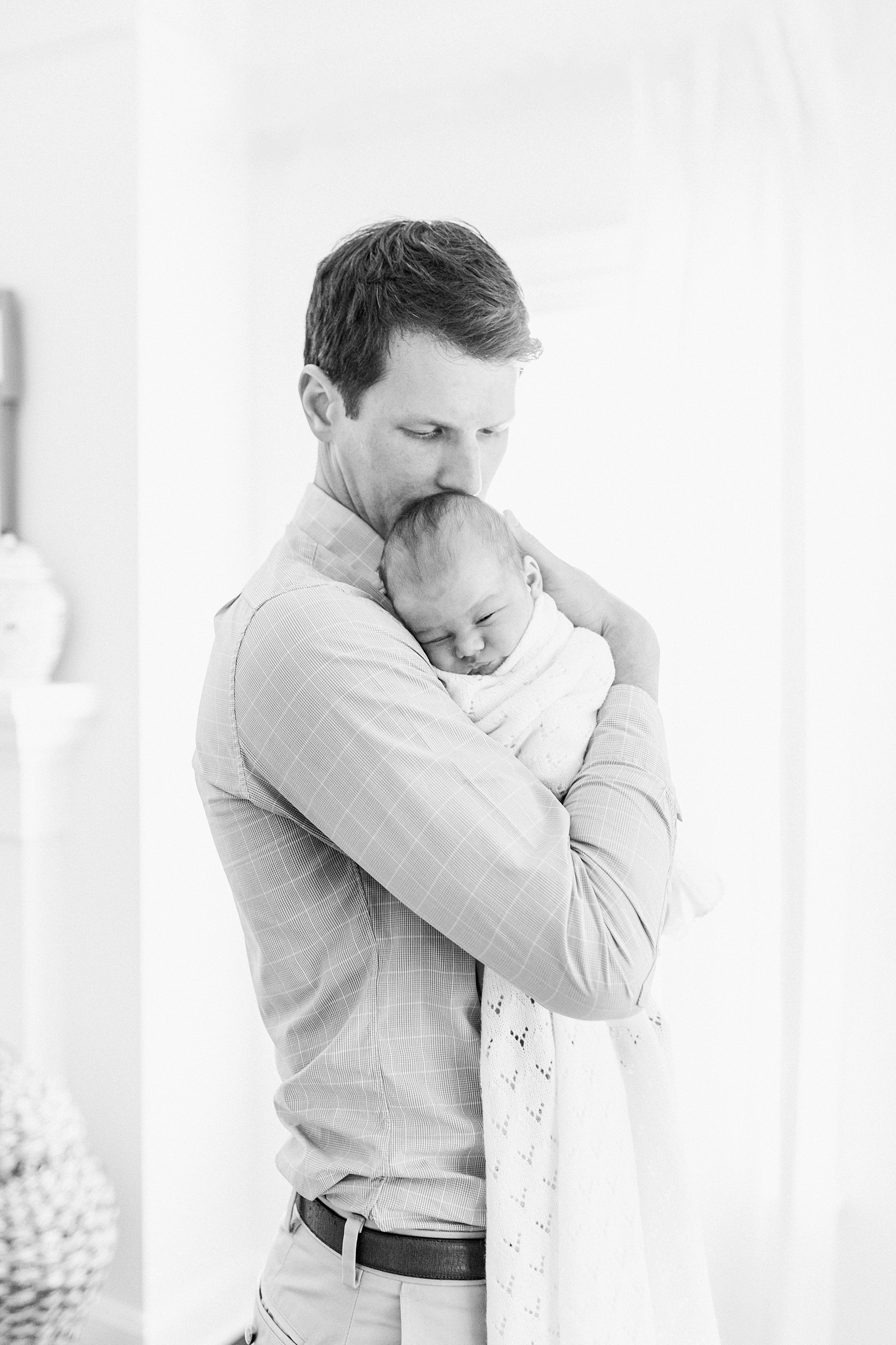 Black and white image of Dad with baby during newborn session by Caitlyn Motycka Photography