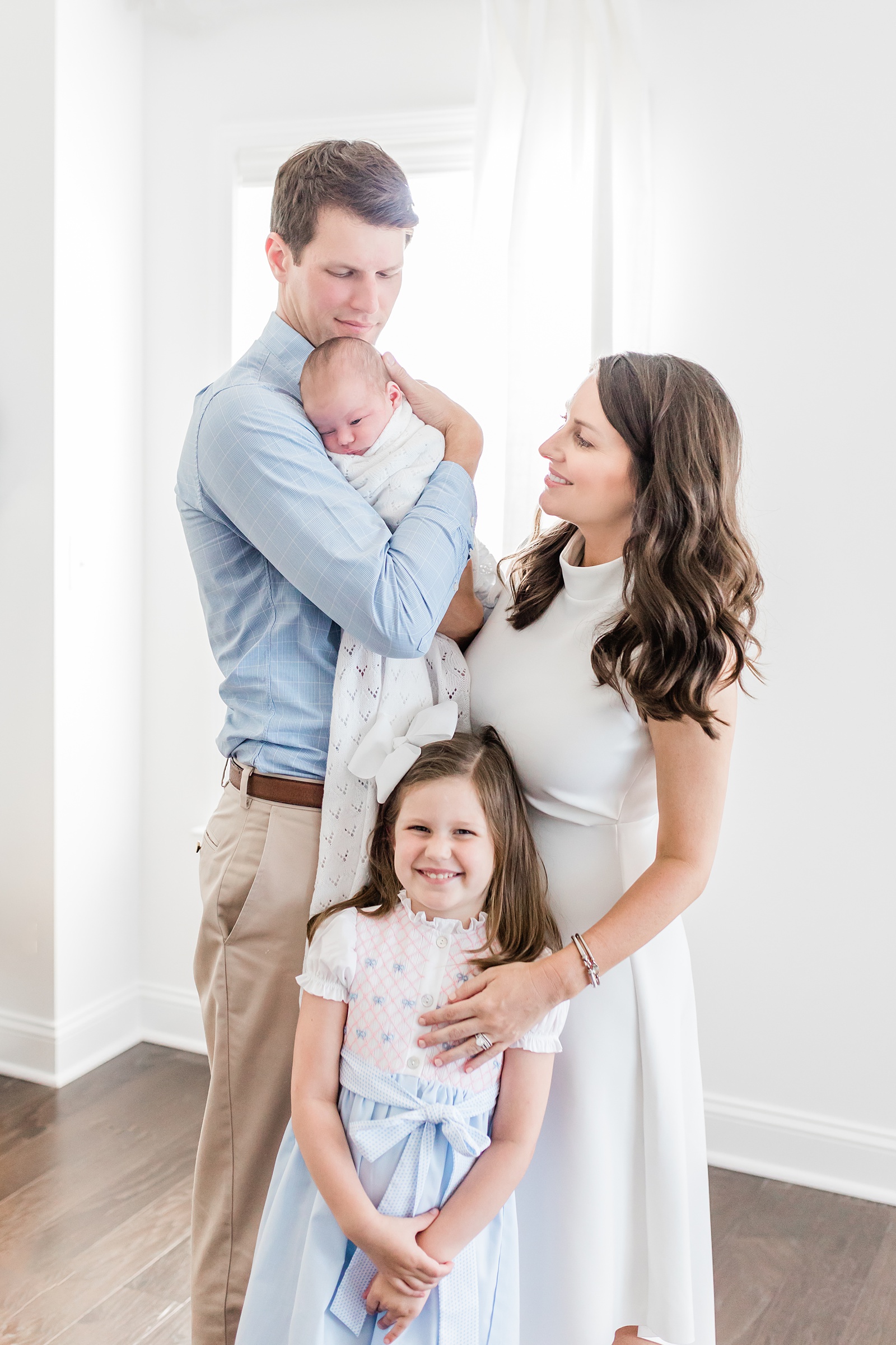 Family with two kids wearing blue and white in lifestyle newborn session by Caitlyn Motycka Photography