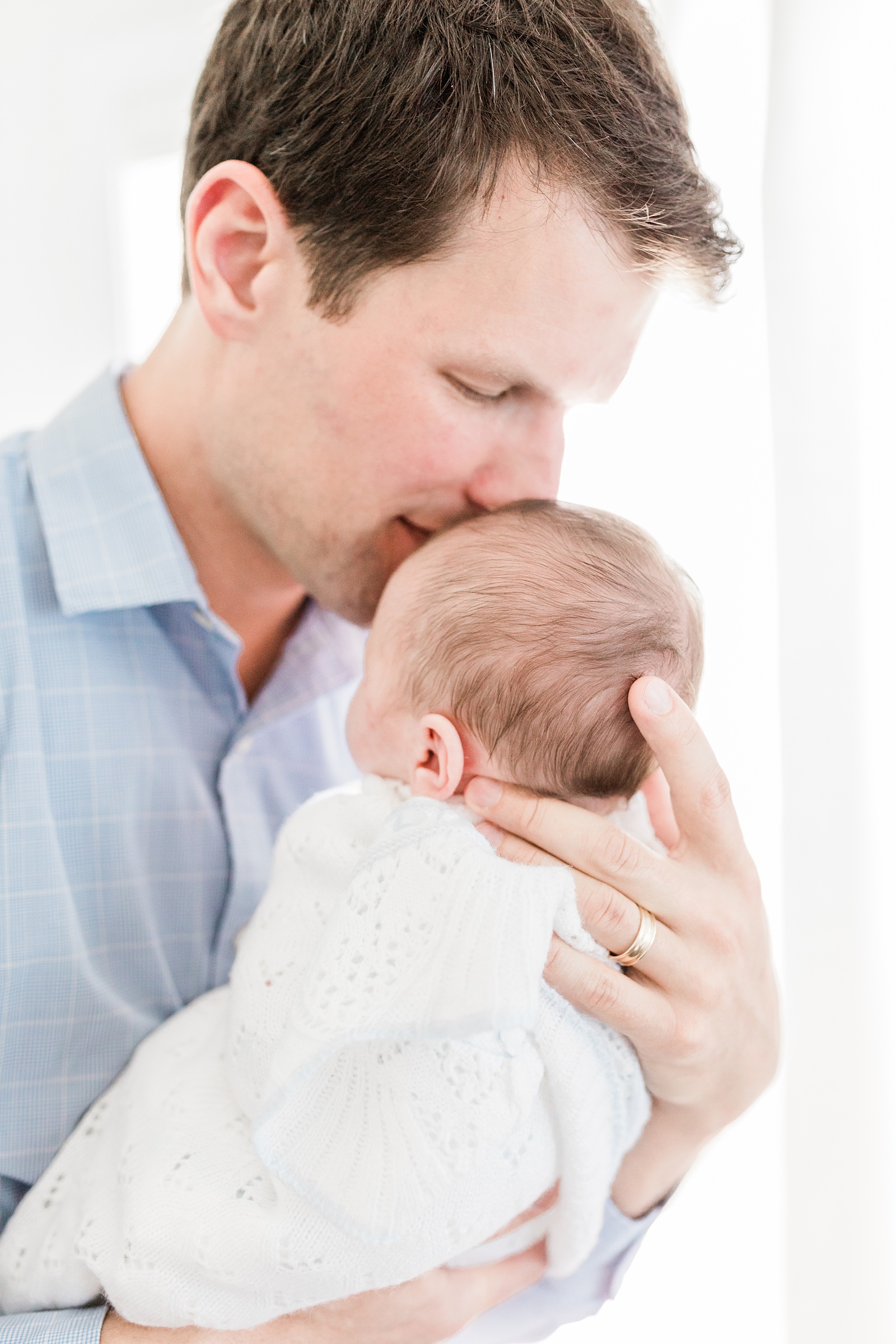 Dad with baby during newborn session by Caitlyn Motycka Photography
