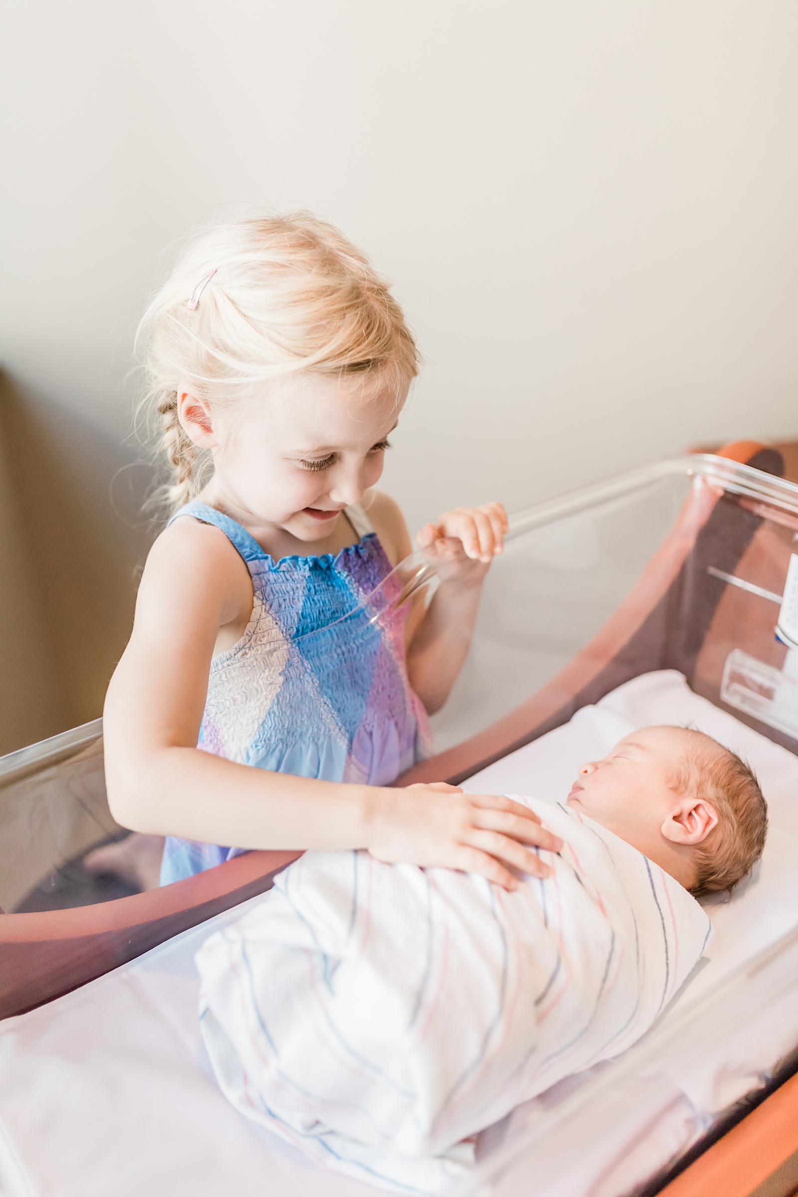 Big sister greeting baby in the hospital by Caitlyn Motycka Photography