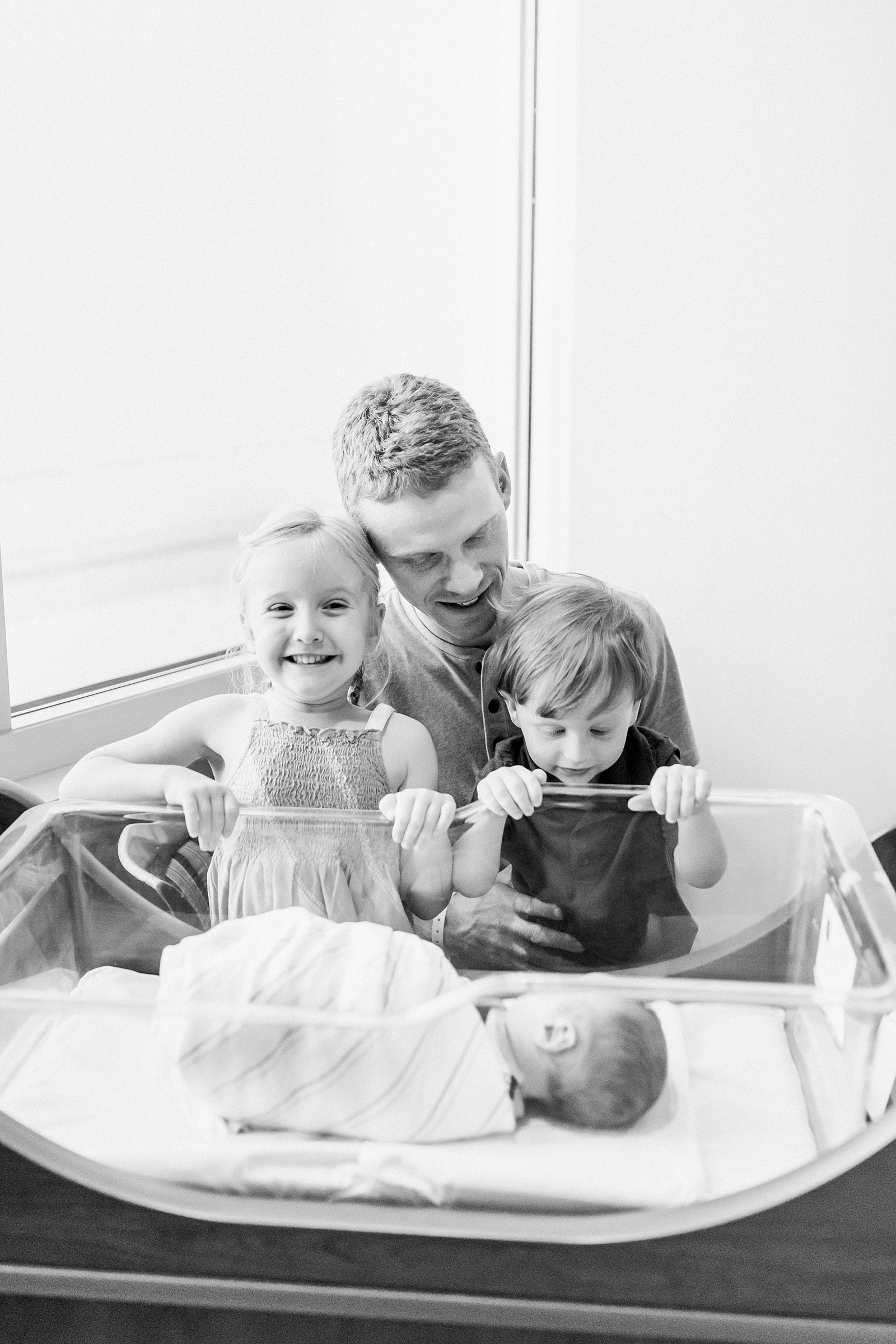 Excited siblings with Dad and newborn at hospital | Caitlyn Motycka Photography