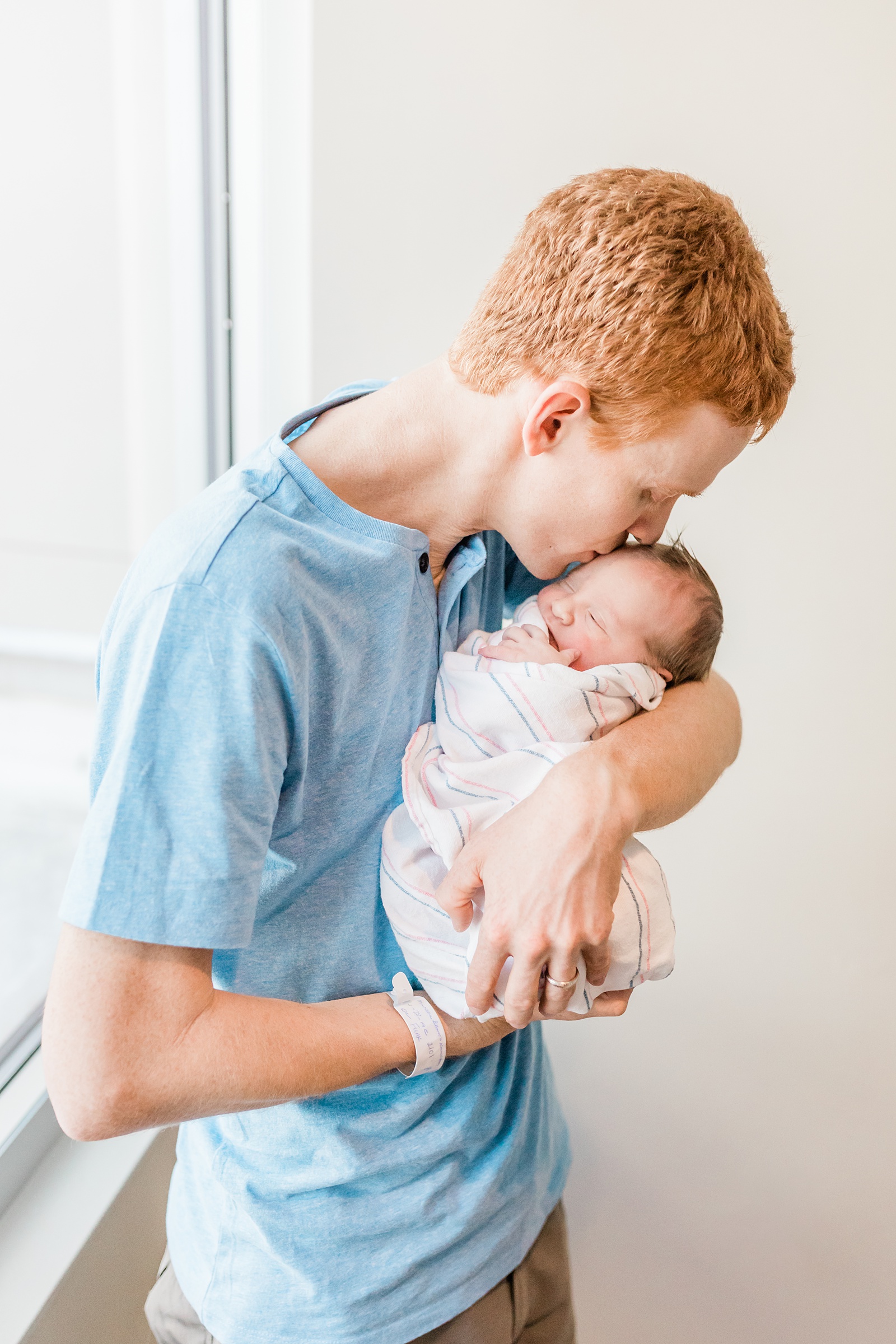 Dad kissing baby in Charleston hospital | Caitlyn Motycka Photography