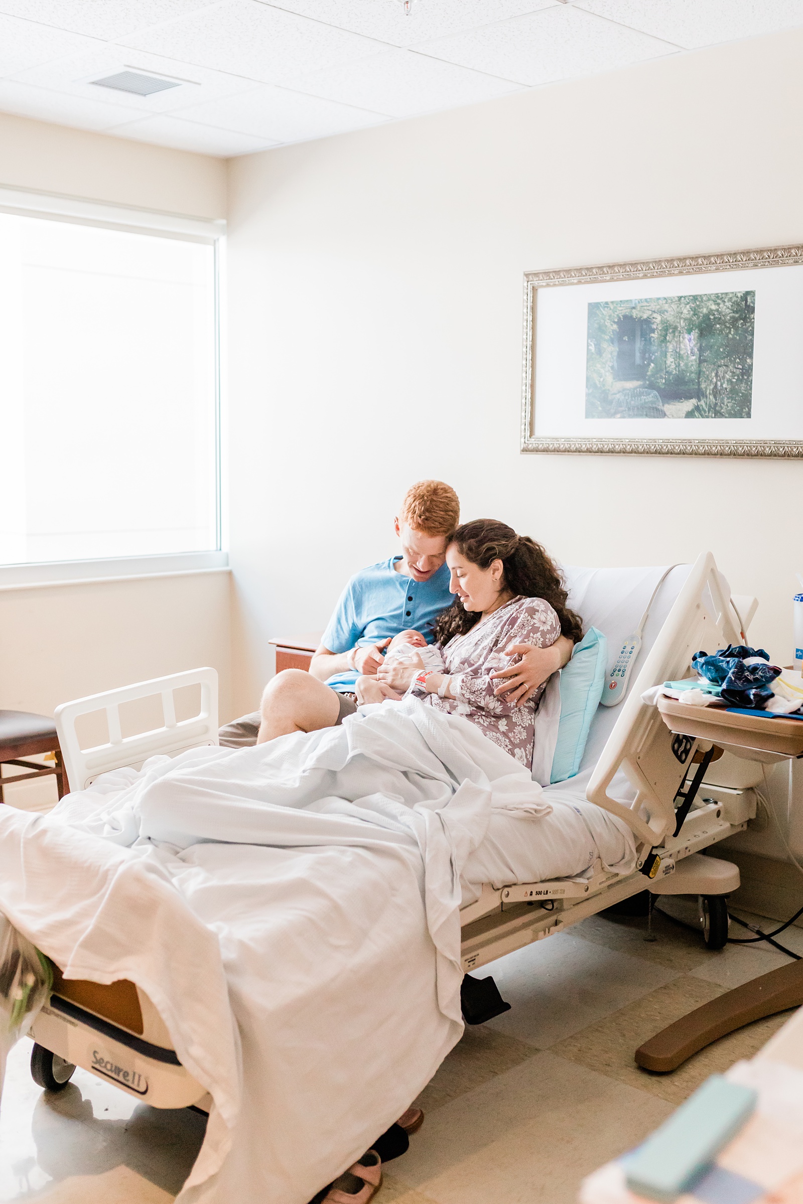 Wide angle photo of parents holding baby in hospital | Caitlyn Motycka Photography