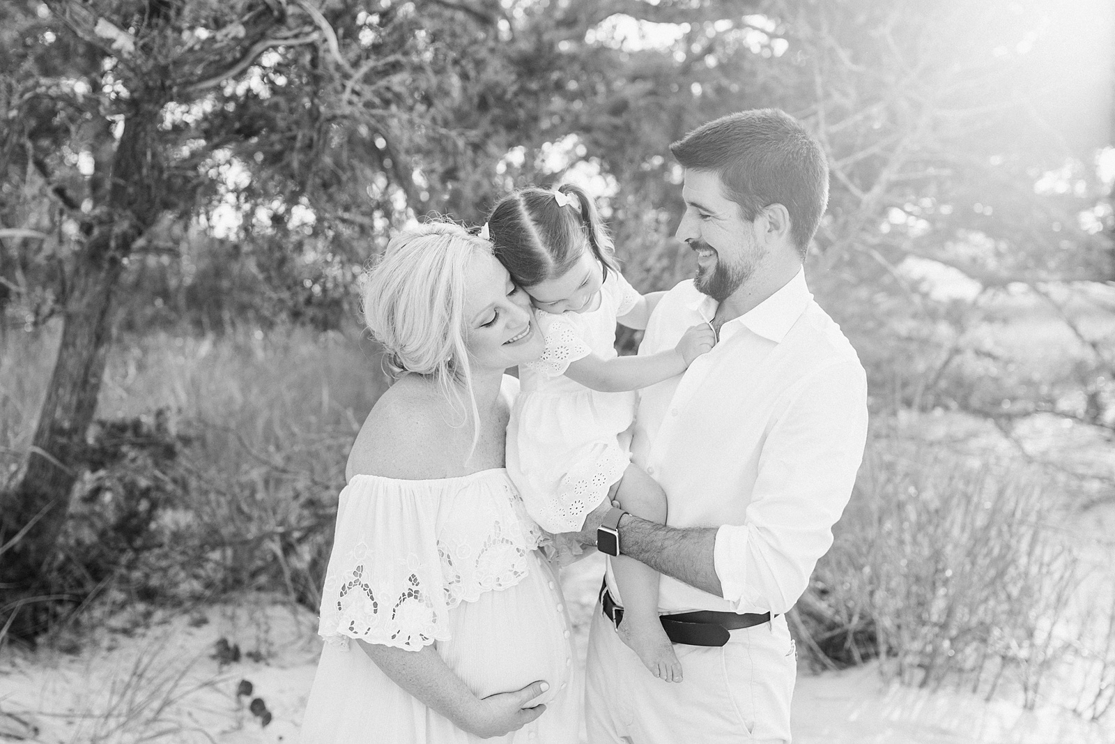 Black and white image of family during maternity session by Caitlyn Motycka Photography