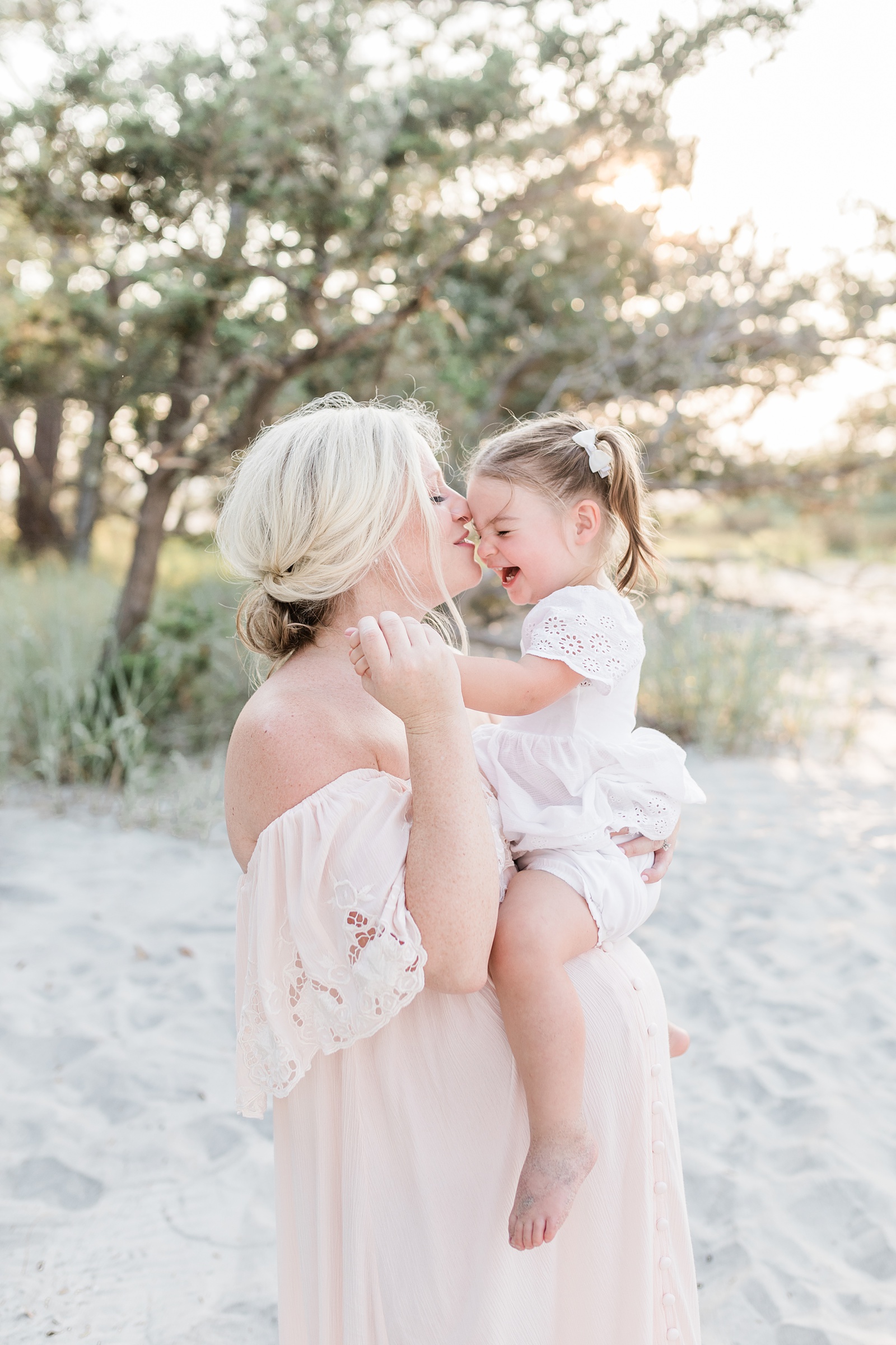 Mom and toddler cuddling during beach maternity session by Caitlyn Motycka Photography