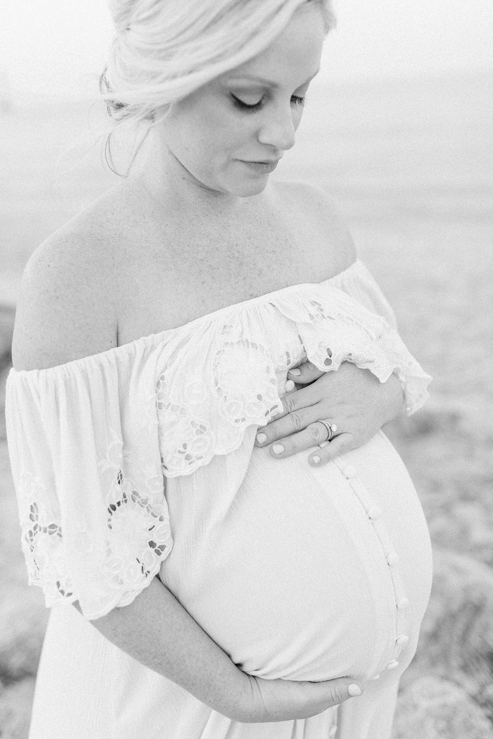 Black and white image of mom during maternity session on Folly Beach by Caitlyn Motycka Photography