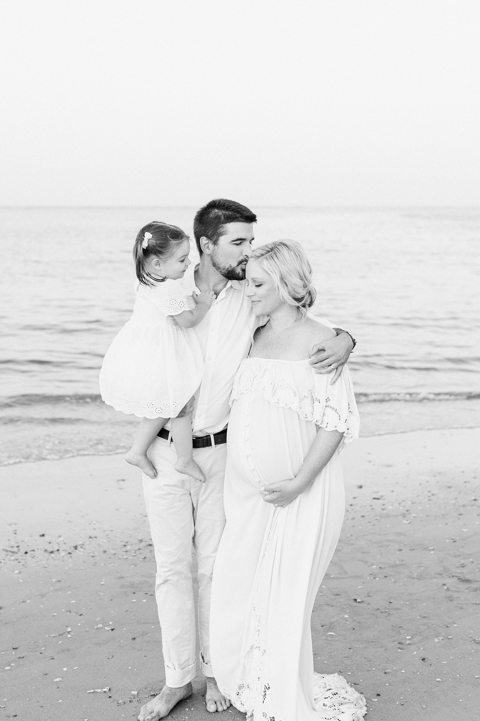 Black and white family beach photo by Charleston Maternity Photographer, Caitlyn Motycka Photography
