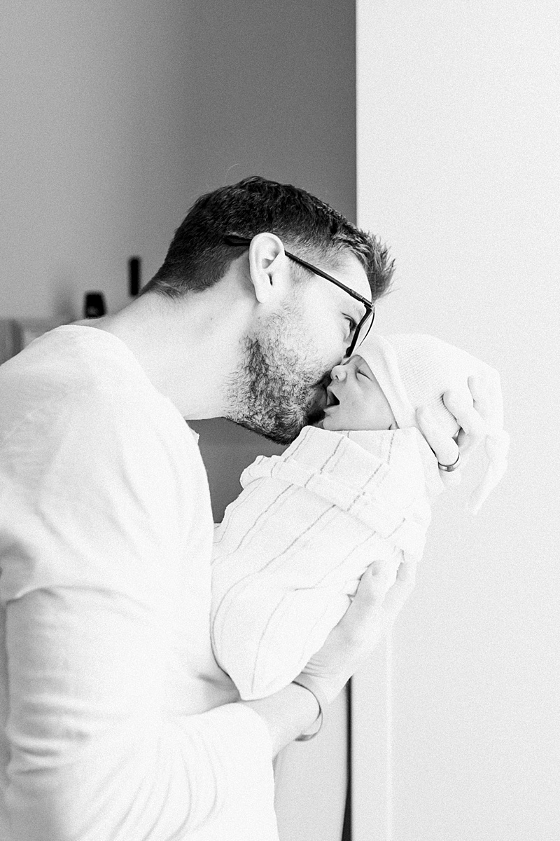Sweet moment of daddy kissing his newborn baby boy during Fresh 48 Hospital newborn photoshoot | Caitlyn Motycka Photography