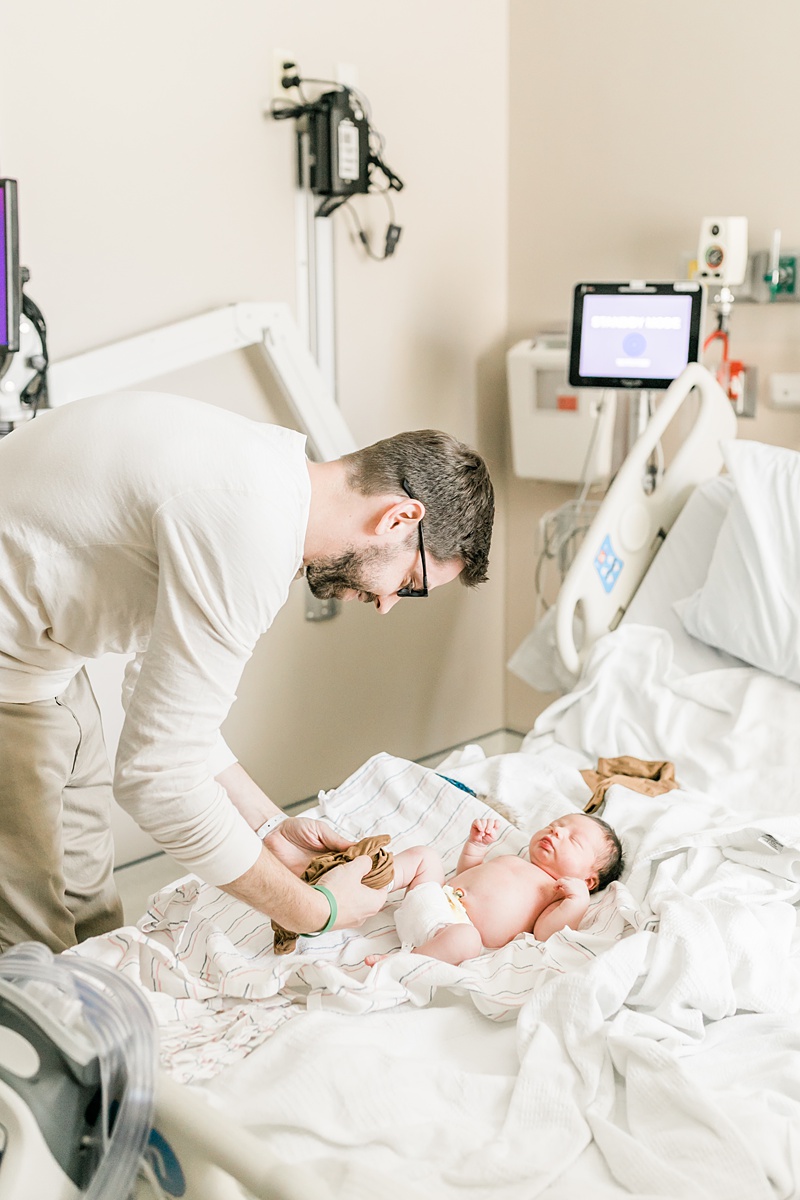 Daddy getting son dressed for hospital newborn photoshoot | Caitlyn Motycka Photography