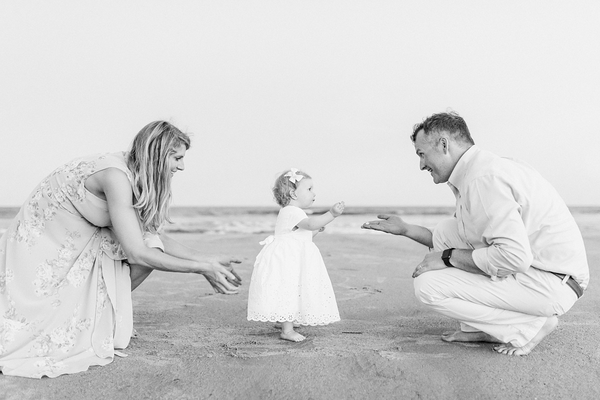 Black and white photo of Mom and Dad with toddler on beach during Charleston family beach photoshoot with Caitlyn Motycka Photography. 