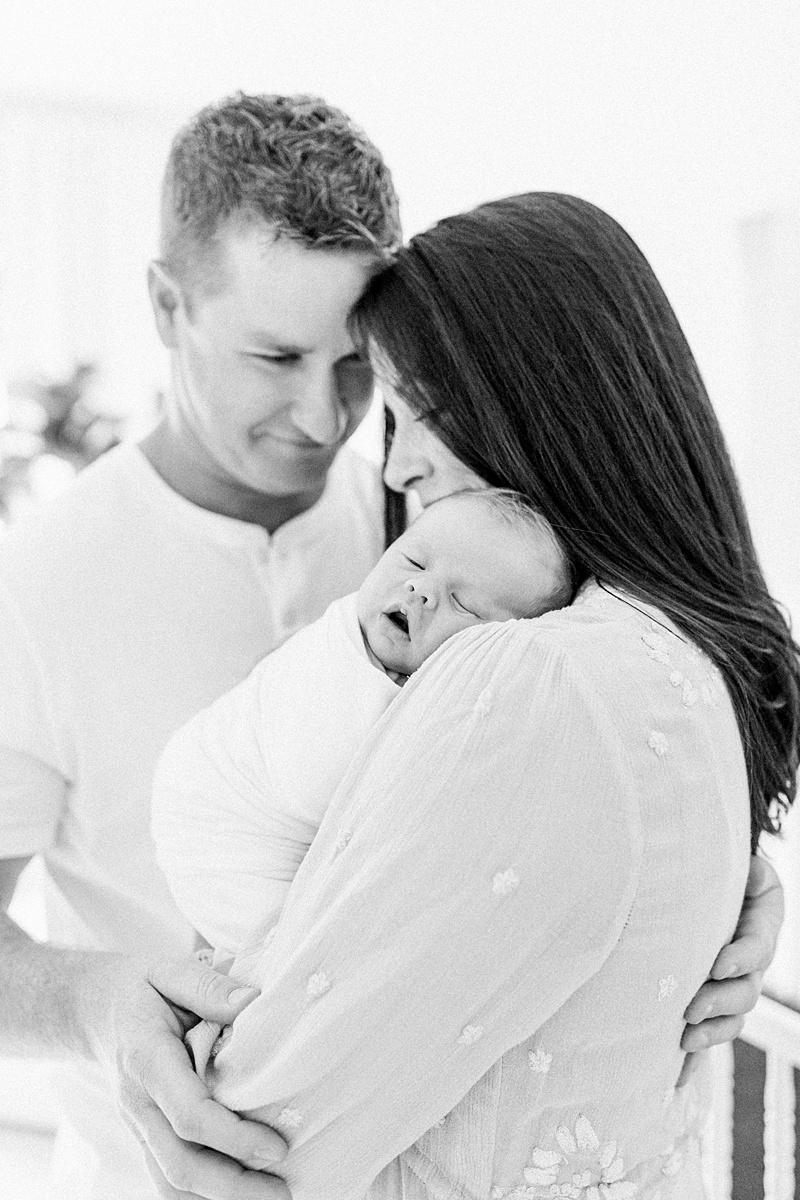 Black and white photo of family during newborn session at Daniel Island home. Photographed by Lifestyle Newborn Photographer, Caitlyn Motycka Photography. 