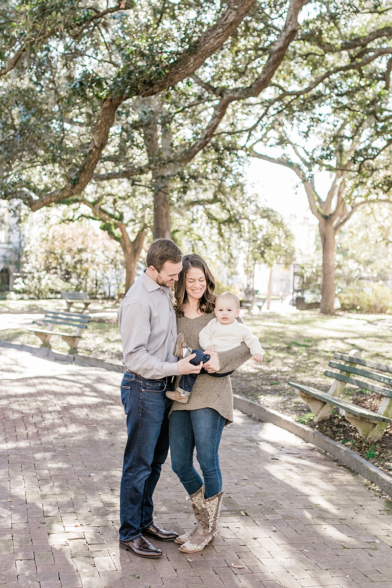 Mom and Dad walking through the park in Downtown Charleston, SC with one year old son. Photos by Charleston Family Photographer, Caitlyn Motycka Photography.