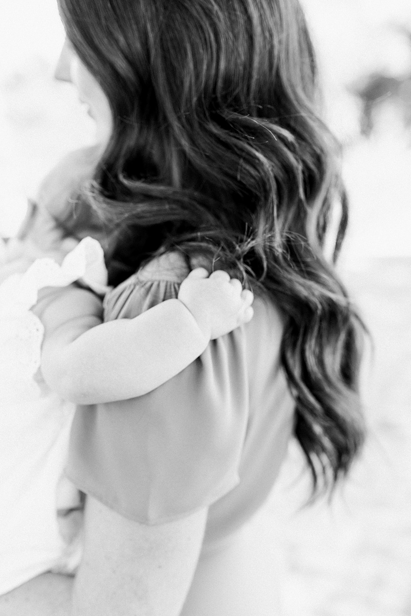 Black and white portrait of a sweet baby girl holding onto her Mama. Photos by Motherhood Photographer, Caitlyn Motycka Photography. 