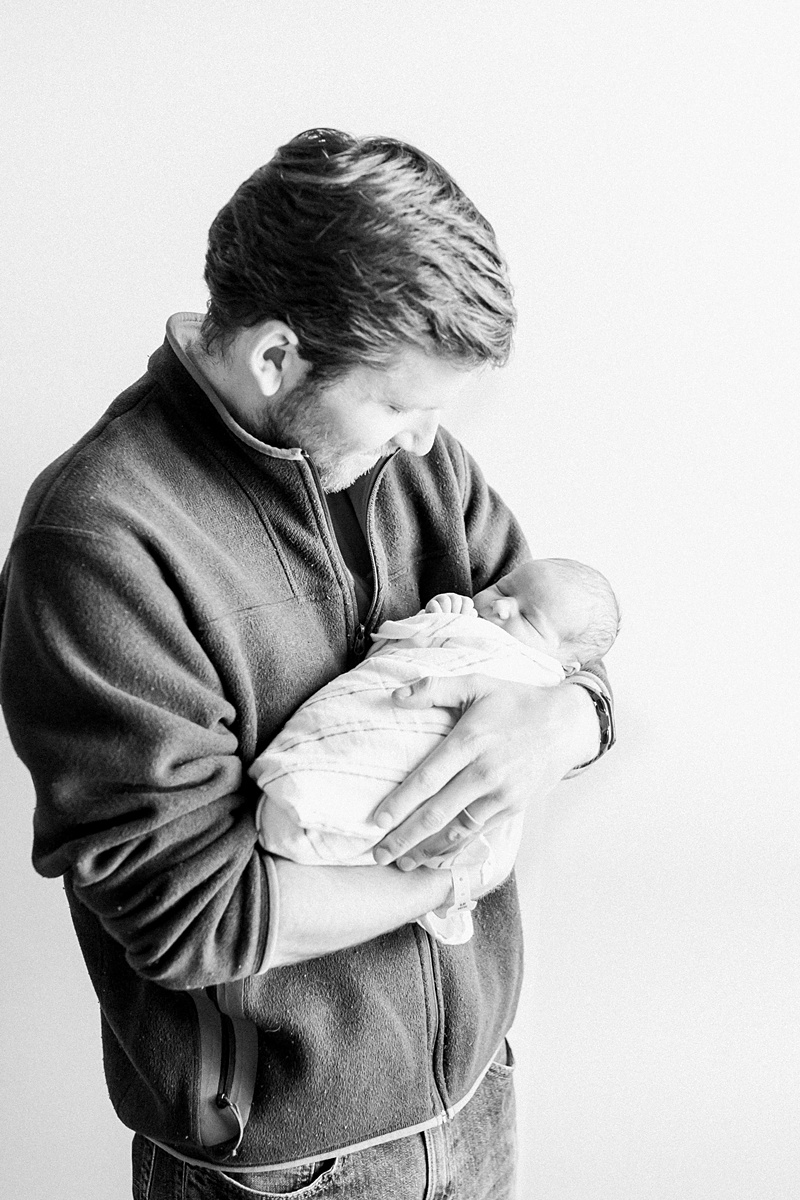 Black and white photo of Dad with his first-born son in the hospital. Photos by Charleston Fresh 48 Photographer, Caitlyn Motycka Photography.