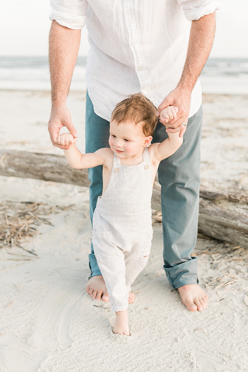 Toddler in grey romper on beach by Charleston Family Photographer, Caitlyn Motycka Photography