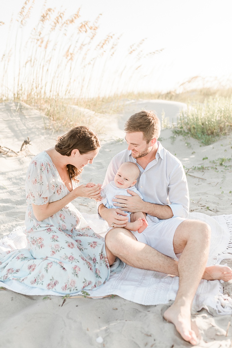 Mom and dad play with baby during family beach session on Isle of Palms in Charleston, SC. Photos by Caitlyn Motycka Photography. 