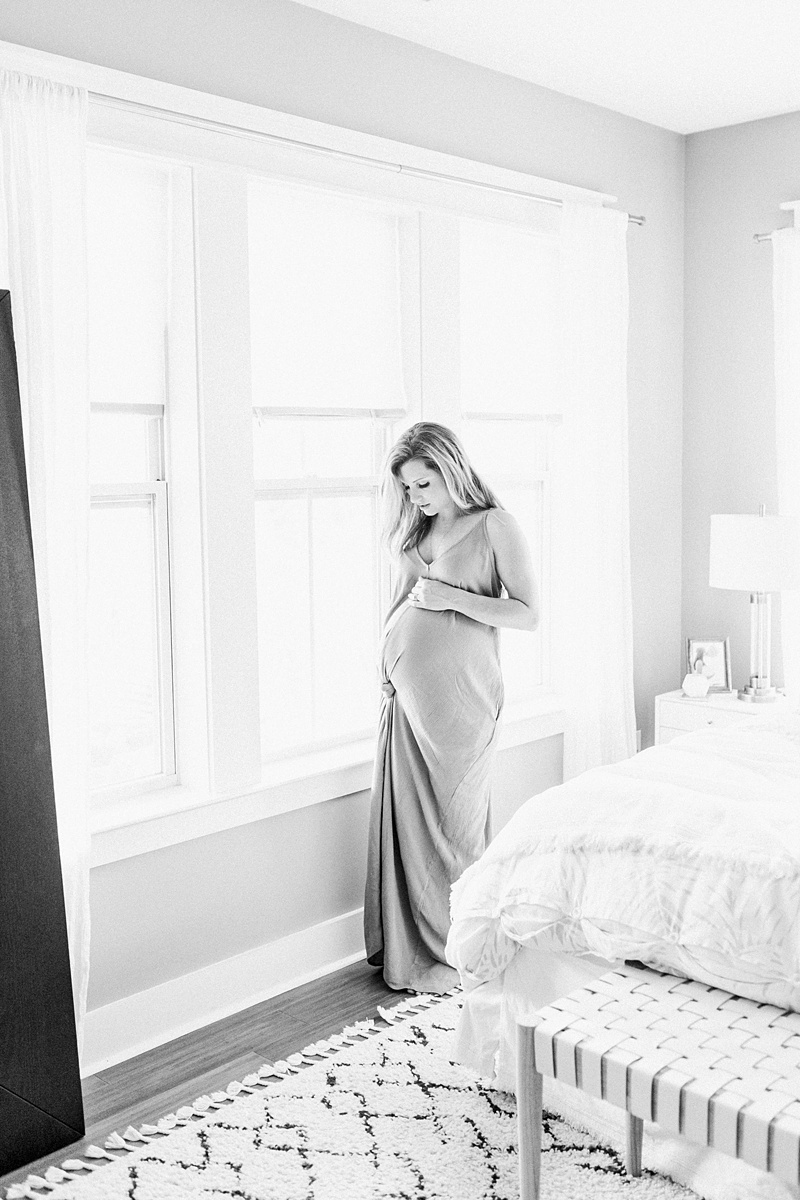 Black and white image of mom in maxi dress in cozy in-home lifestyle maternity session by Charleston Maternity Photographer, Caitlyn Motycka Photography