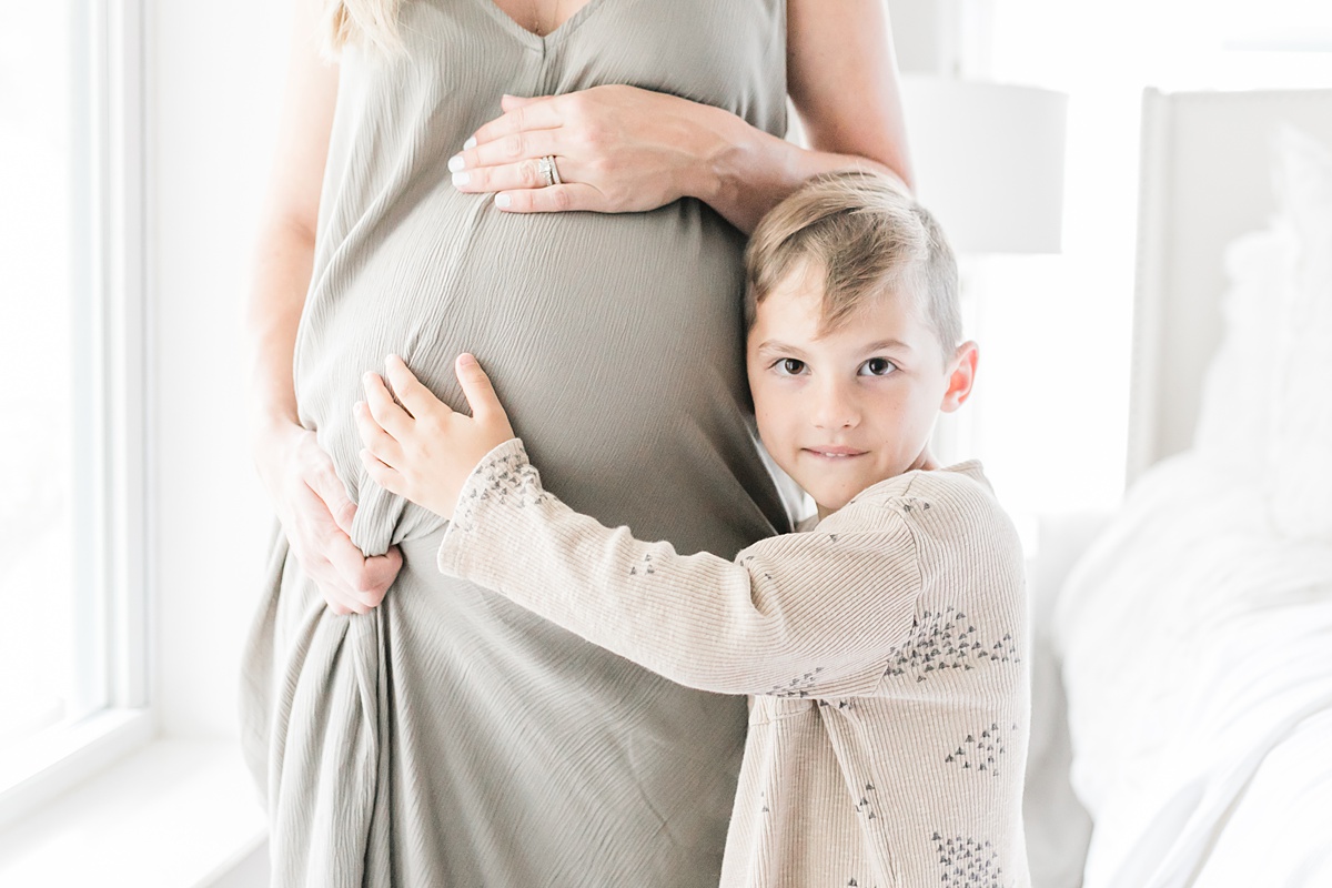 Mom with son during light and airy in-home lifestyle maternity session by Caitlyn Motycka Photography