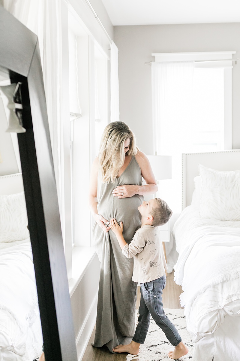 Mom with child during light and airy in-home lifestyle maternity session by Charleston Maternity Photographer, Caitlyn Motycka Photography