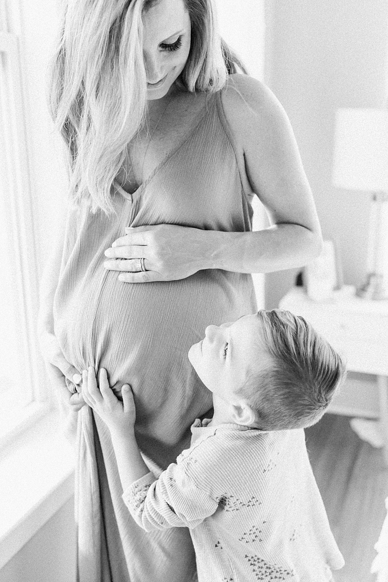 Black and white images of mom with son during light and airy in-home lifestyle maternity session by Caitlyn Motycka Photography
