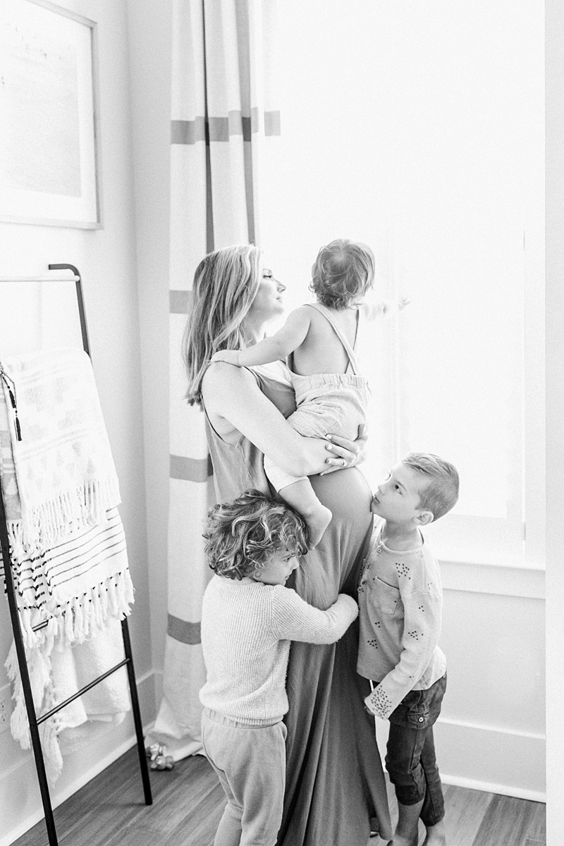 Black and white image of mom with kids from in-home lifestyle maternity session | Caitlyn Motycka Photography
