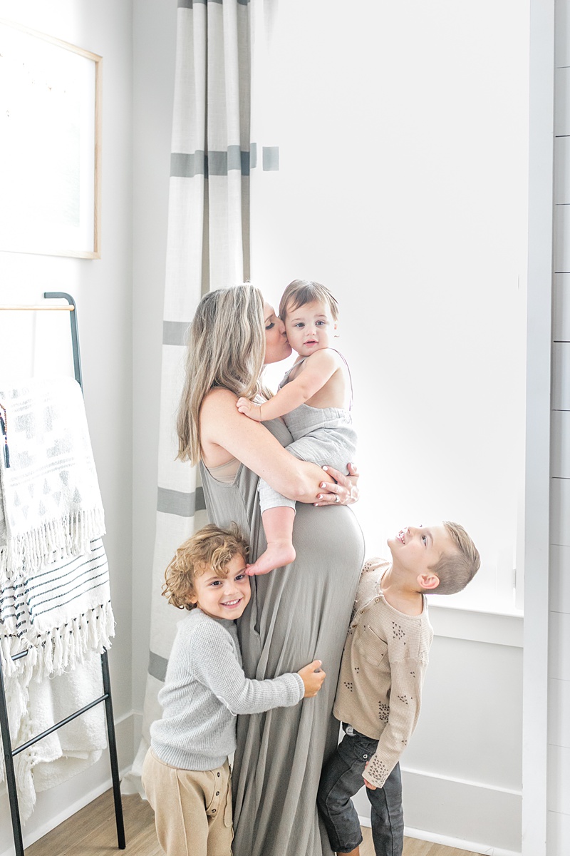 Kids cuddling mom's bump during in-home lifestyle maternity session by Charleston Maternity Photographer, Caitlyn Motycka Photography