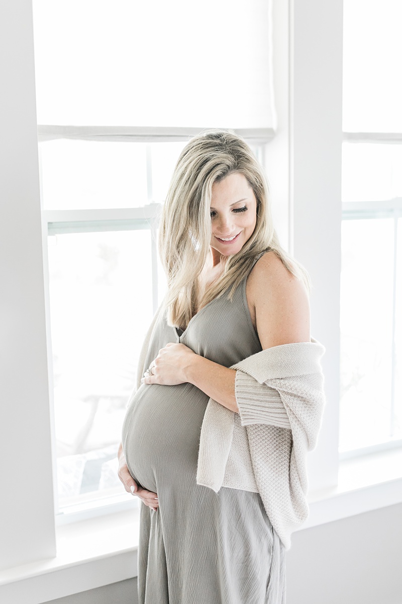 Maternity photo of mom in maxi dress and sweater by Caitlyn Motycka Photography