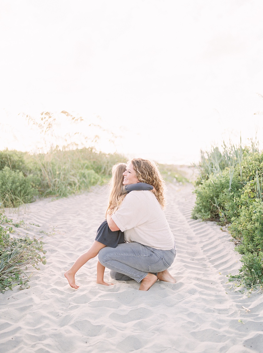 Mama with her littles during family photoshoot on Folly Beach. Photos by Charleston Film Photographer, Caitlyn Motycka Photography.