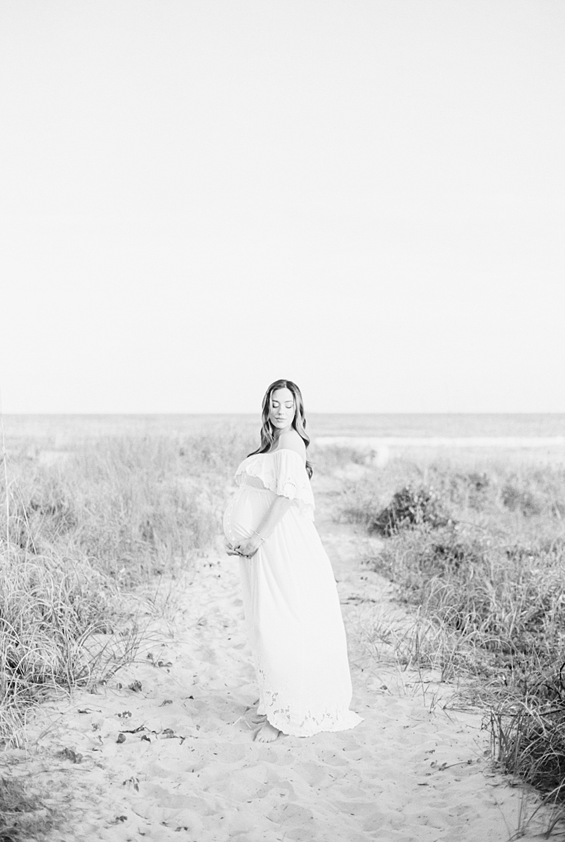 Black and white photos of Mama carrying twins. Photos at Isle of Palms Beach by Caitlyn Motycka Photography. 