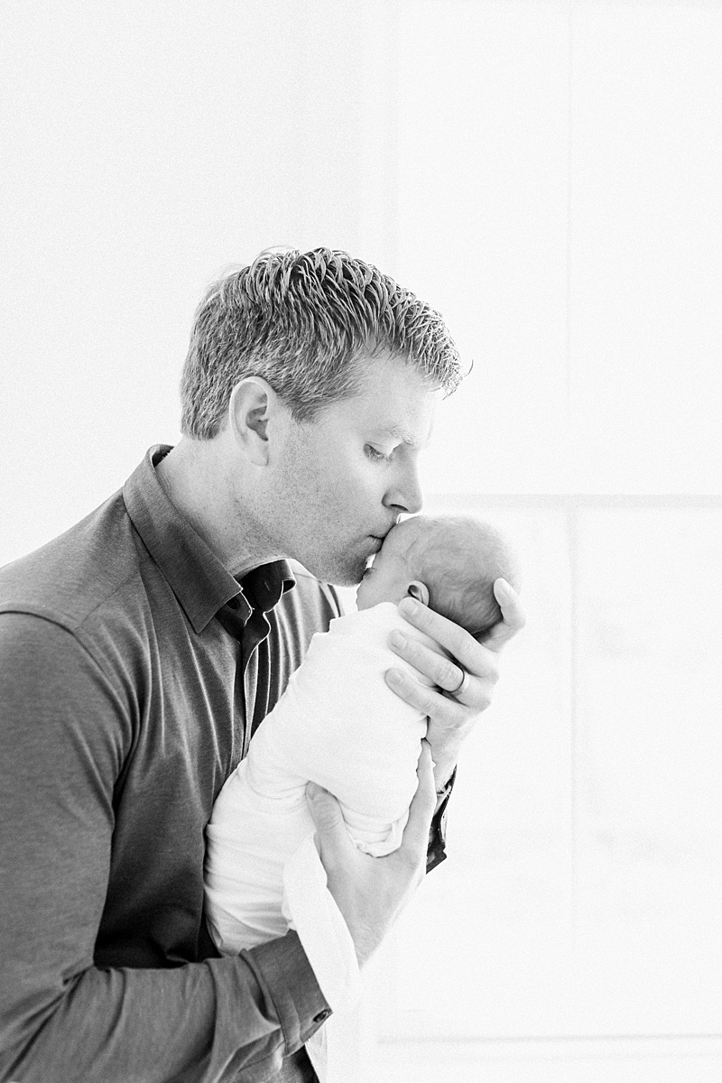 Black and white photo of Father and son during Daniel Island Newborn Session. Photos by Daniel Island Newborn Photographer, Caitlyn Motycka Photography. 