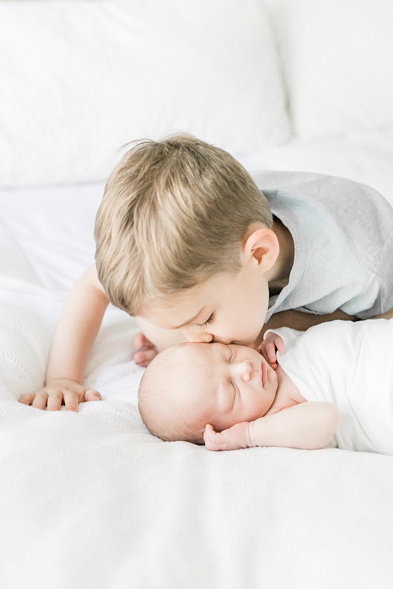 Big brother kissing baby brother at newborn session in Mount Pleasant. Photos by Caitlyn Motycka Photography. 