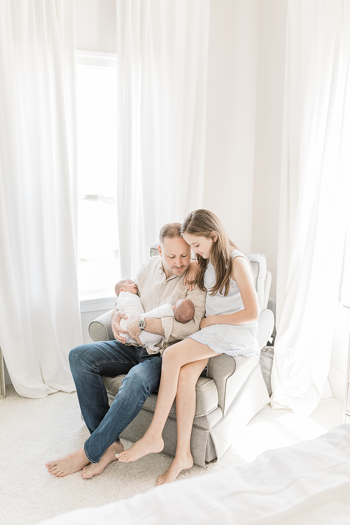 Dad with big sister and baby brothers during in-home newborn session in Charleston, SC. Photos by Caitlyn Motycka Photography.