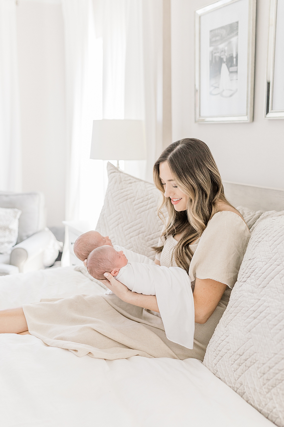 Mom holding her newborn twin boys during lifestyle newborn session in Charleston, SC. Photos by Caitlyn Motycka Photography.