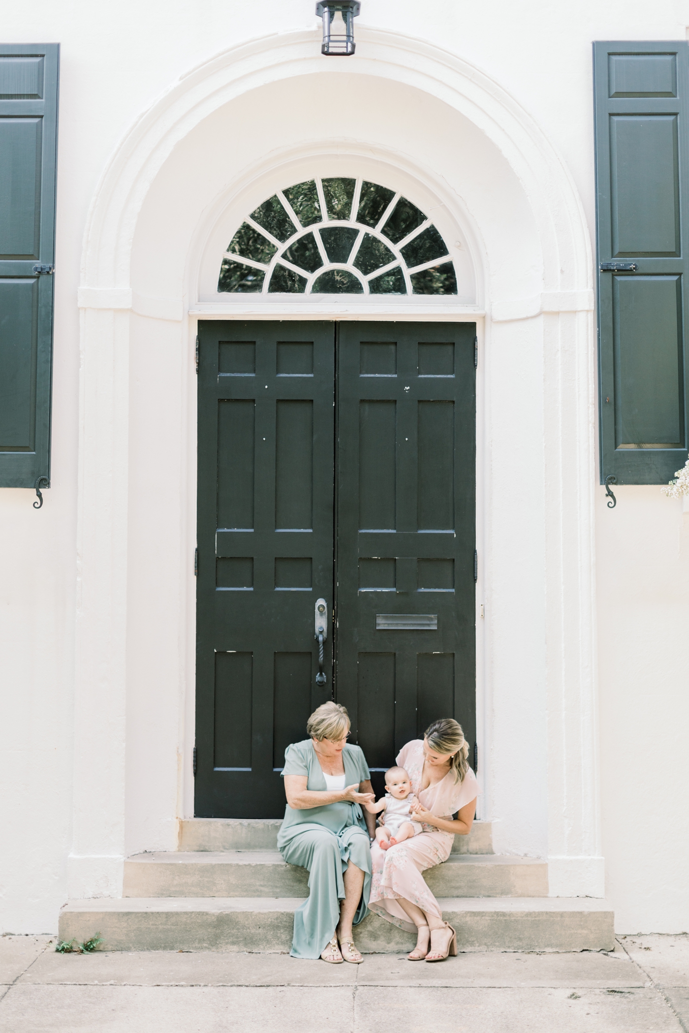 Grandma, Mom, and baby sitting in doorway of historic Charleston building. Photo by Charleston Family Photographer, Caitlyn Motycka Photography.