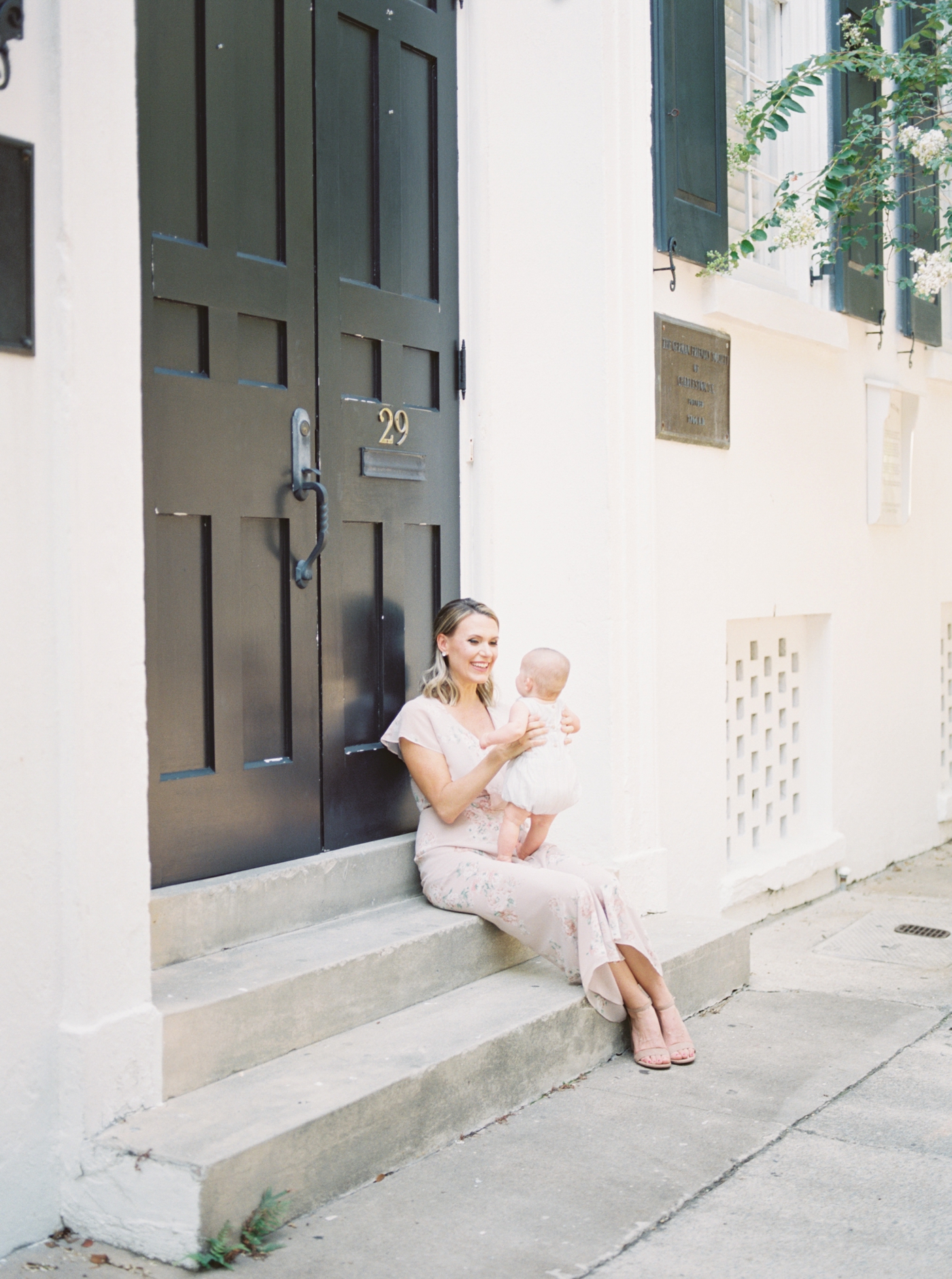 Mom with baby on film in historic Charleston. Photo by Motherhood and Family Photographer, Caitlyn Motycka Photography.