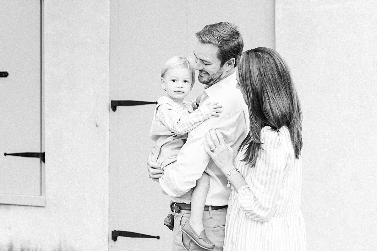 Black and white family portrait of parents and son during a photoshoot downtown with Charleston Family Photographer, Caitlyn Motycka Photography.