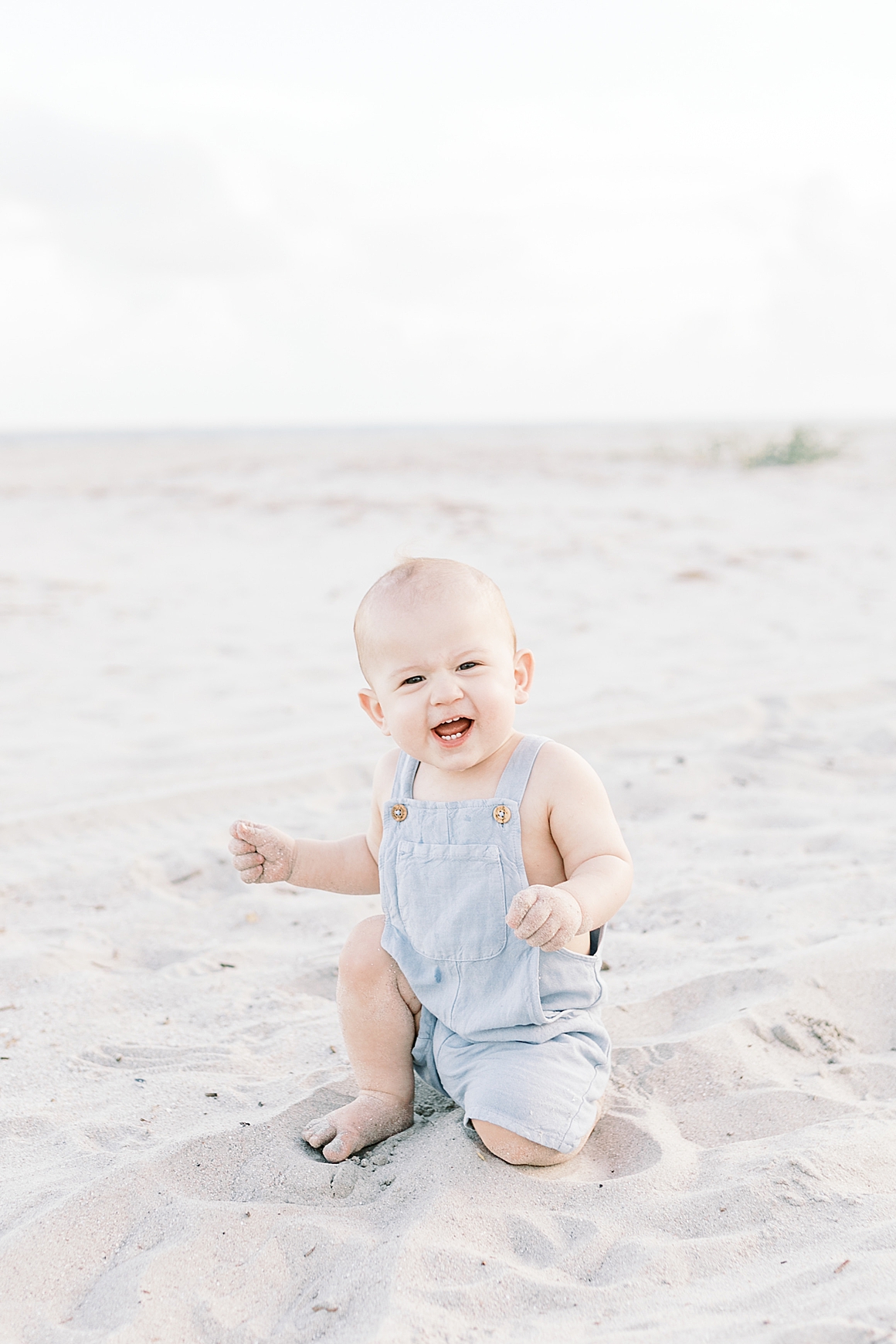 Little boy in blue romper during first birthday milestone session in Charleston, SC. Photos by Caitlyn Motycka Photography