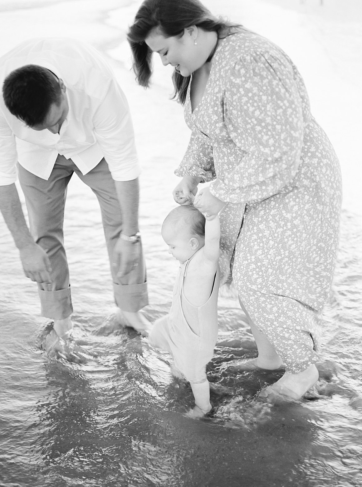 Black and white photo of family playing in the water at IOP in Charleston, SC. Photos by Caitlyn Motycka Photography. 