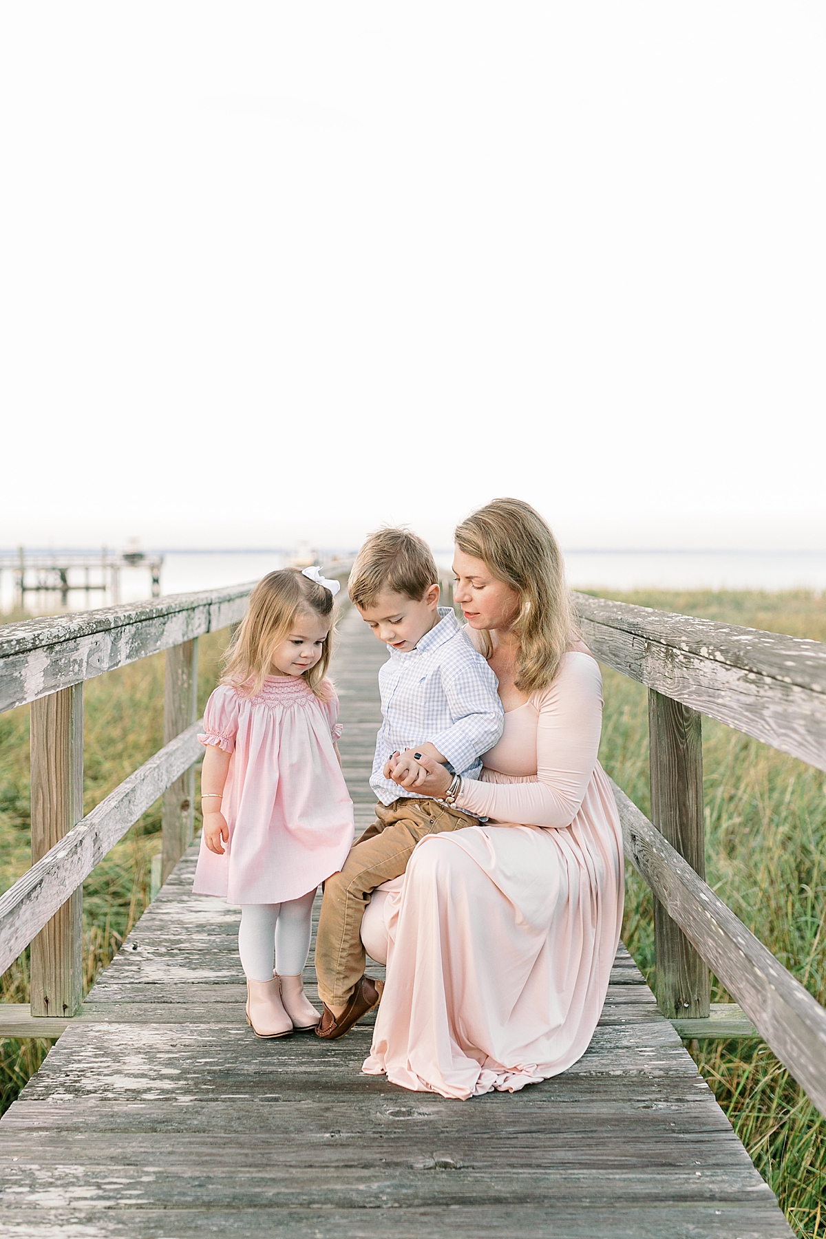 Mom with kids on the dock during family photoshoot. Photos by Mount Pleasant Family Photographer, Caitlyn Motycka Photography.