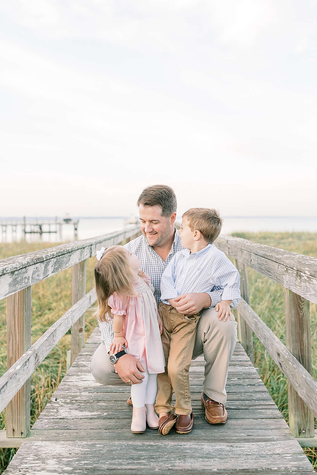 Dad with kids on the dock during family photoshoot. Photos by Mount Pleasant Family Photographer, Caitlyn Motycka Photography.