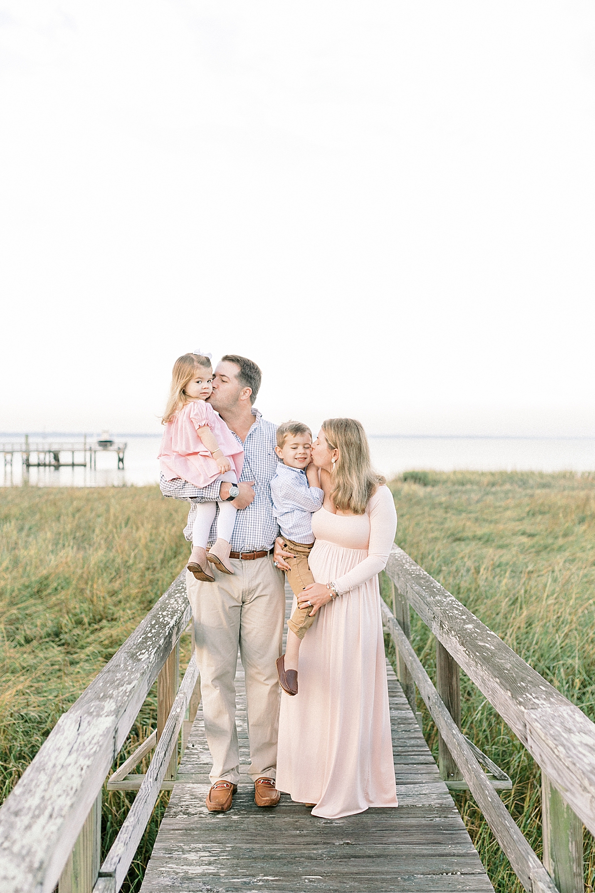 Family cuddling on dock in Old Village of Mount Pleasant, SC during family photoshoot with Caitlyn Motycka Photography.