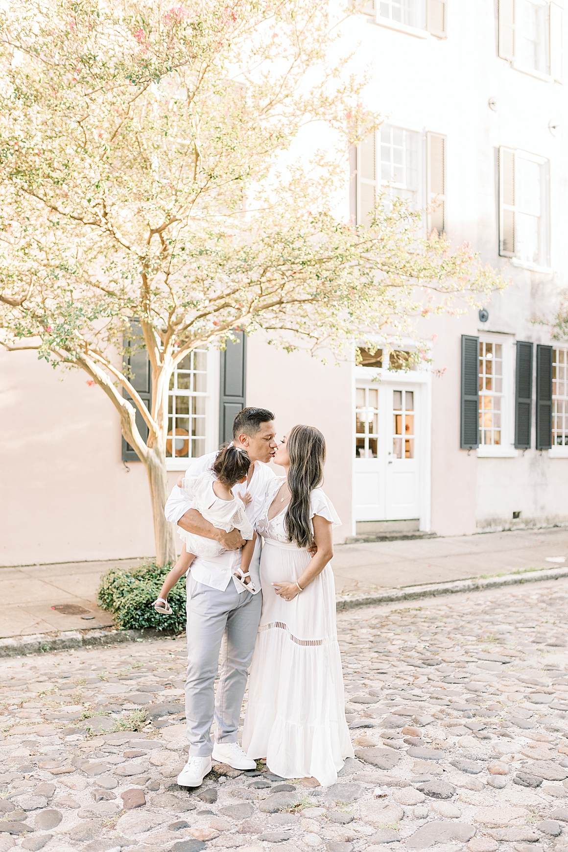 Mom and Dad give each other a kiss during family photoshoot over the summer in downtown. Photos by Charleston Photographer, Caitlyn Motycka Photography.
