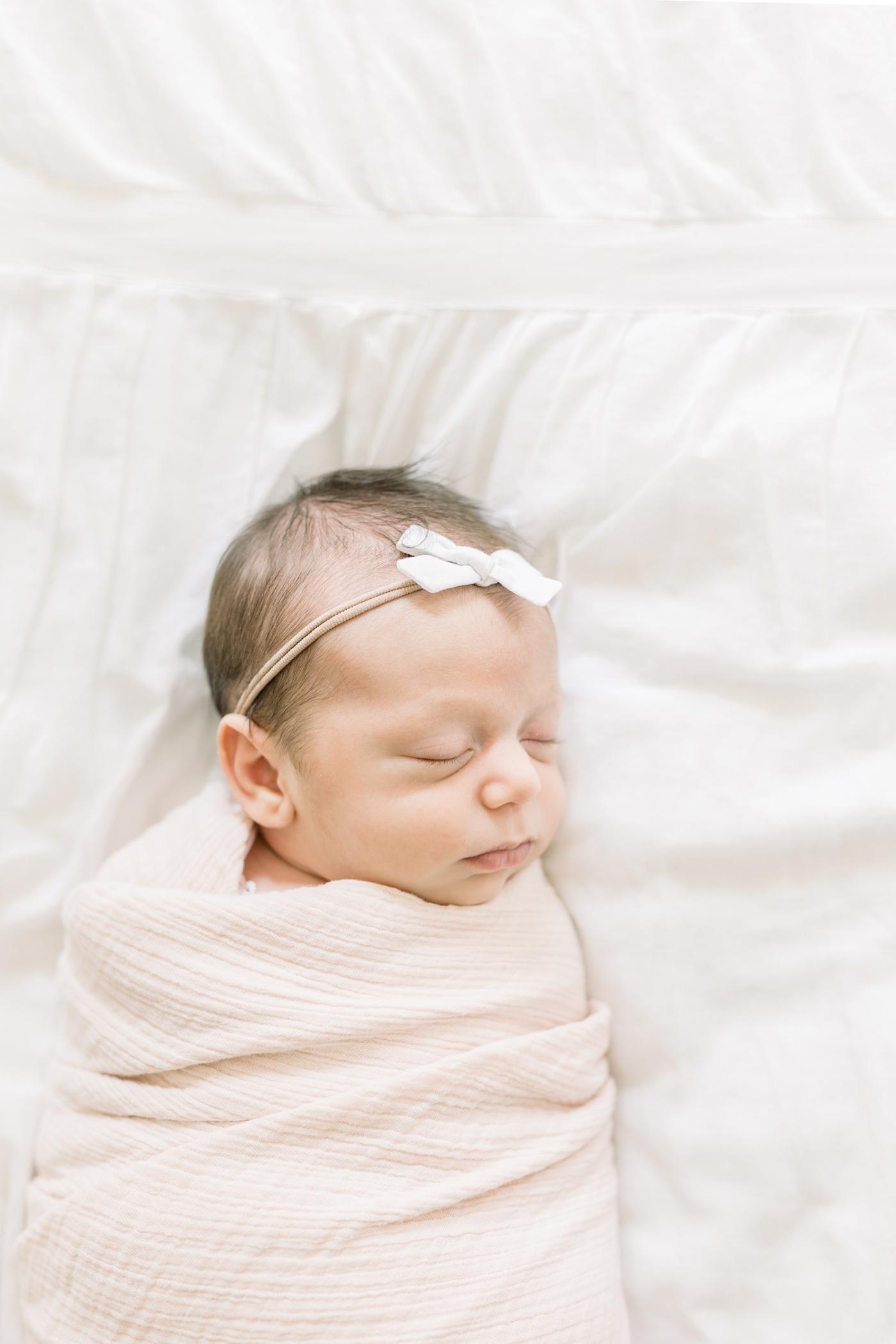 Baby girl wrapped in pink swaddle sleeping during newborn session in Mount Pleasant, SC. Photo by Caitlyn Motycka Photography.